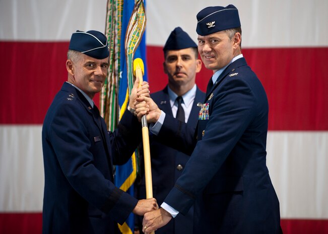 Col. Richard Boutwell (right), 99th Air Base Wing commander, accepts command of the 99th ABW from Maj. Gen. Jay Silveria, U.S. Air Force Warfare Center commander at the Thunderbird hangar, June 27, 2014, Nellis Air Force Base, Nev. Boutwell is coming from the Pentagon where he was responsible for providing assessments on a portfolio in excess of $755 billion. (U.S. Air Force photo by Airman 1st Class Thomas Spangler)