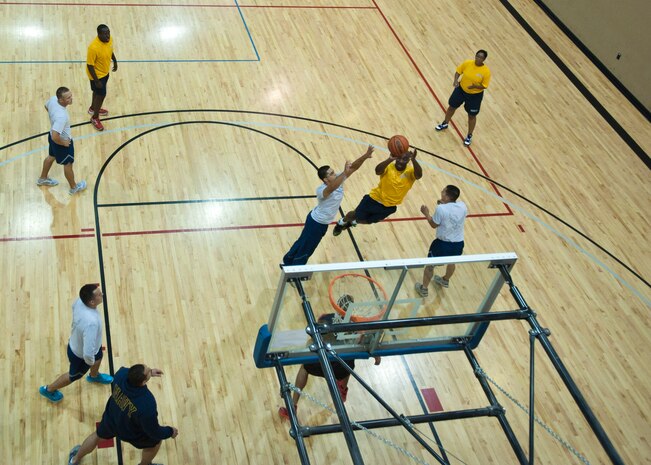 U.S. Navy sailors play basketball against U.S. Air Force Airmen at the Warrior Fitness Center, June 27, 2014, Nellis Air Force Base, Nev. Maintaining physical fitness doesn’t mean just running endless miles and doing hundreds of push-ups. One can stay in shape simply by participating in active games and activities. (U.S. Air Force photo by Senior Airman Timothy Young)