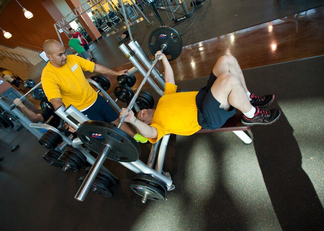 U.S. Navy Petty Officer 2nd Class Fernando Castro (left), a recruiter with the Naval Recruiting Station Las Vegas, spots Petty Officer 2nd Class Christopher Jones, a recruiter with the NRS Las Vegas, at the Warrior Fitness Center, June 27, 2014, Nellis Air Force Base, Nev. Maintaining peak physical fitness is essential for military recruiters because they are the face of the military for prospective recruits. (U.S. Air Force photo by Senior Airman Timothy Young) 