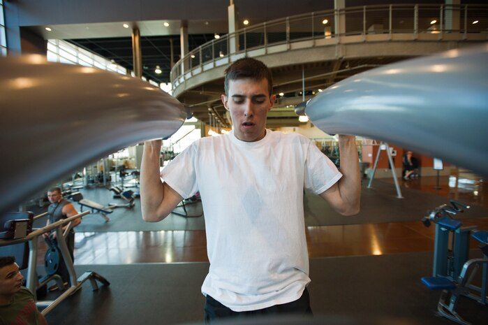 Airman 1st Class Evan Nuber, a munitions storage crewmember assigned to the 31st Munitions Squadron, Aviano Air Base, Italy, preforms pull-ups at the Warrior Fitness Center, June 27, 2014, Nellis Air Force Base, Nev. The Warrior Fitness Center has a variety of machines and weights available for Airmen and the Nellis community. (U.S. Air Force photo by Senior Airman Timothy Young)