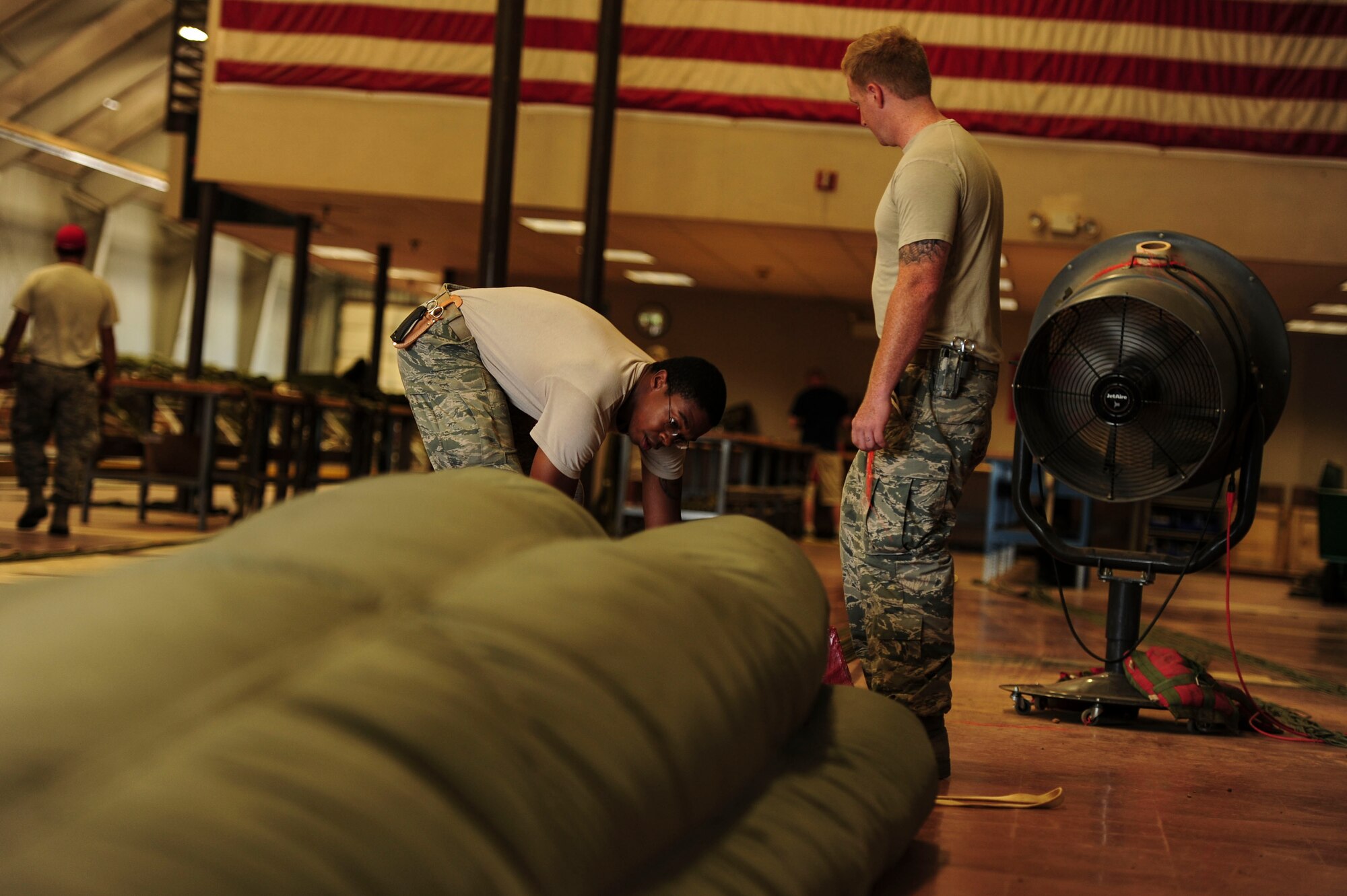 Senior Airman Demarc Shorter, a 19th Logistics Readiness Squadron aerial delivery journeyman, airs a G12 parachute June 27, 2014, at Little Rock Air Force Base, Ark. Each parachute msut be checked for holes or broken lines prior to packing. (U.S. Air Force photo by Senior Airman Kaylee Clark)