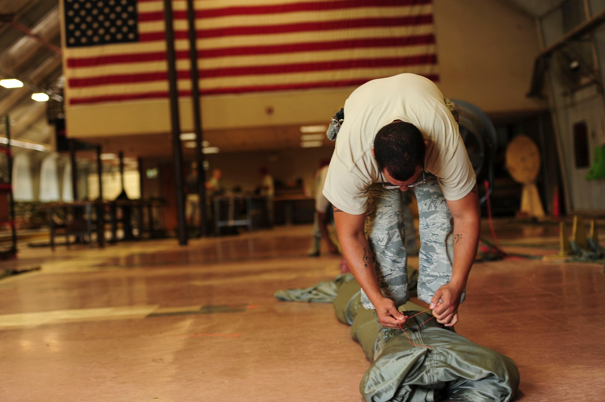 Senior Airman Jamie Broussard, a 19th Logistics Readiness Squadron aerial delivery journeyman, prepares a G12 parachute June 27, 2014, at Little Rock Air Force Base, Ark. On, average riggers from the 19th LRS prepare 10 pallets for delivery each day. (U.S. Air Force photo by Senior Airman Kaylee Clark)