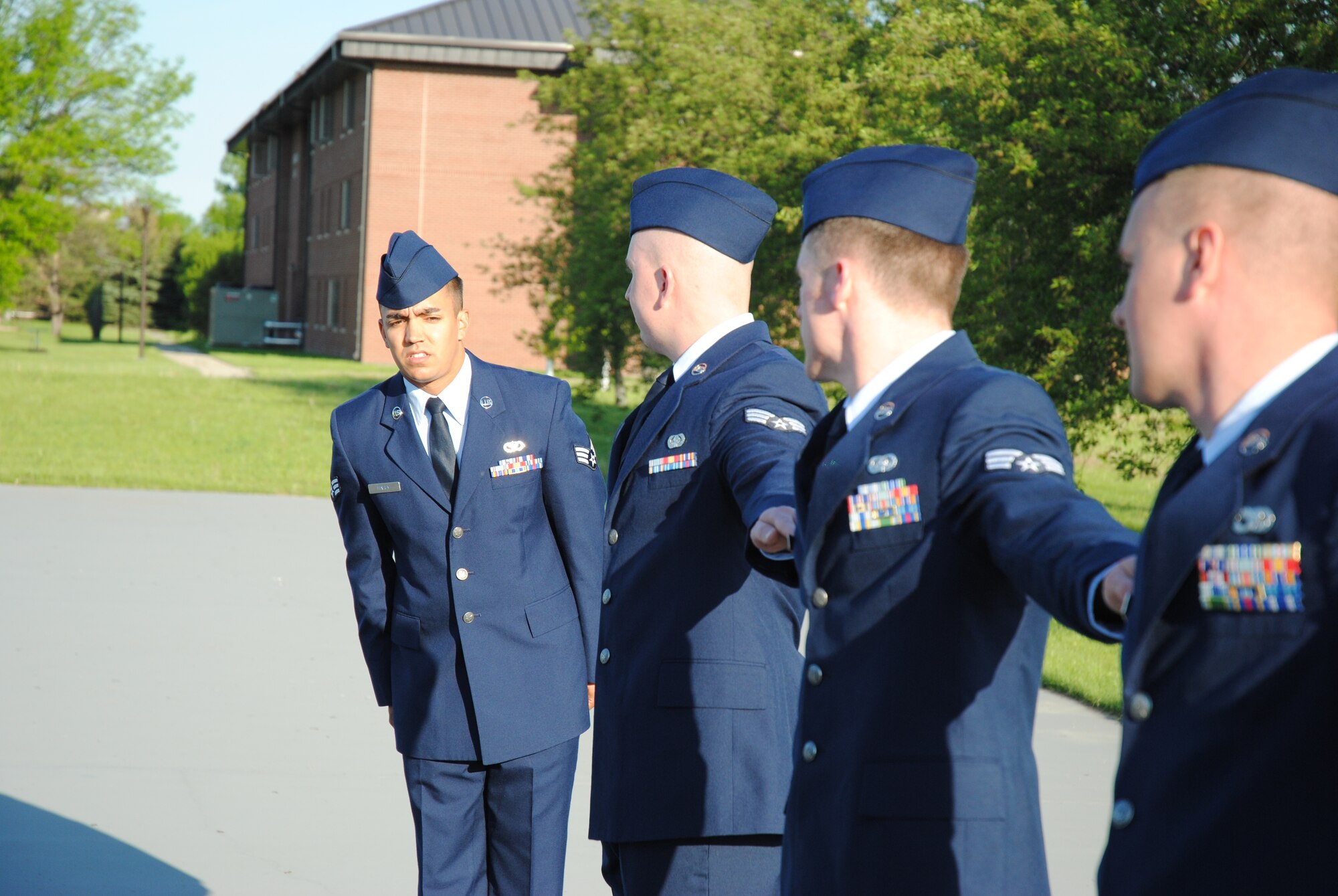 Senior Airman Justin Haley, ALS Class 14-Echo active-duty flight class leader, ensures his classmates are sized and lined up correctly during a uniform inspection conducted June 4, 2014, at the drill pad located next to the Chief Master Sgt. Richard L. Etchberger Airman Leadership School on Grand Forks Air Force Base, N.D. Class 14-E was made up by two student flights. One flight consisted of 12 active-duty Airmen completing their in-residence course at the Etchberger ALS in Grand Forks AFB, while the other flight was made up of a dozen Air National Guard Airmen from the 119th Wing attending an in-residence ALS course at the North Dakota ANG base in Fargo, N.D. Both of the flights were simultaneously taught by Air Force active-duty instructors from the Etchberger ALS. This new approach on training was the first of its kind according to officials from the 119th Wing and the 319th Air Base Wing. (U.S. Air Force photo/Staff Sgt. Luis Loza Gutierrez)
