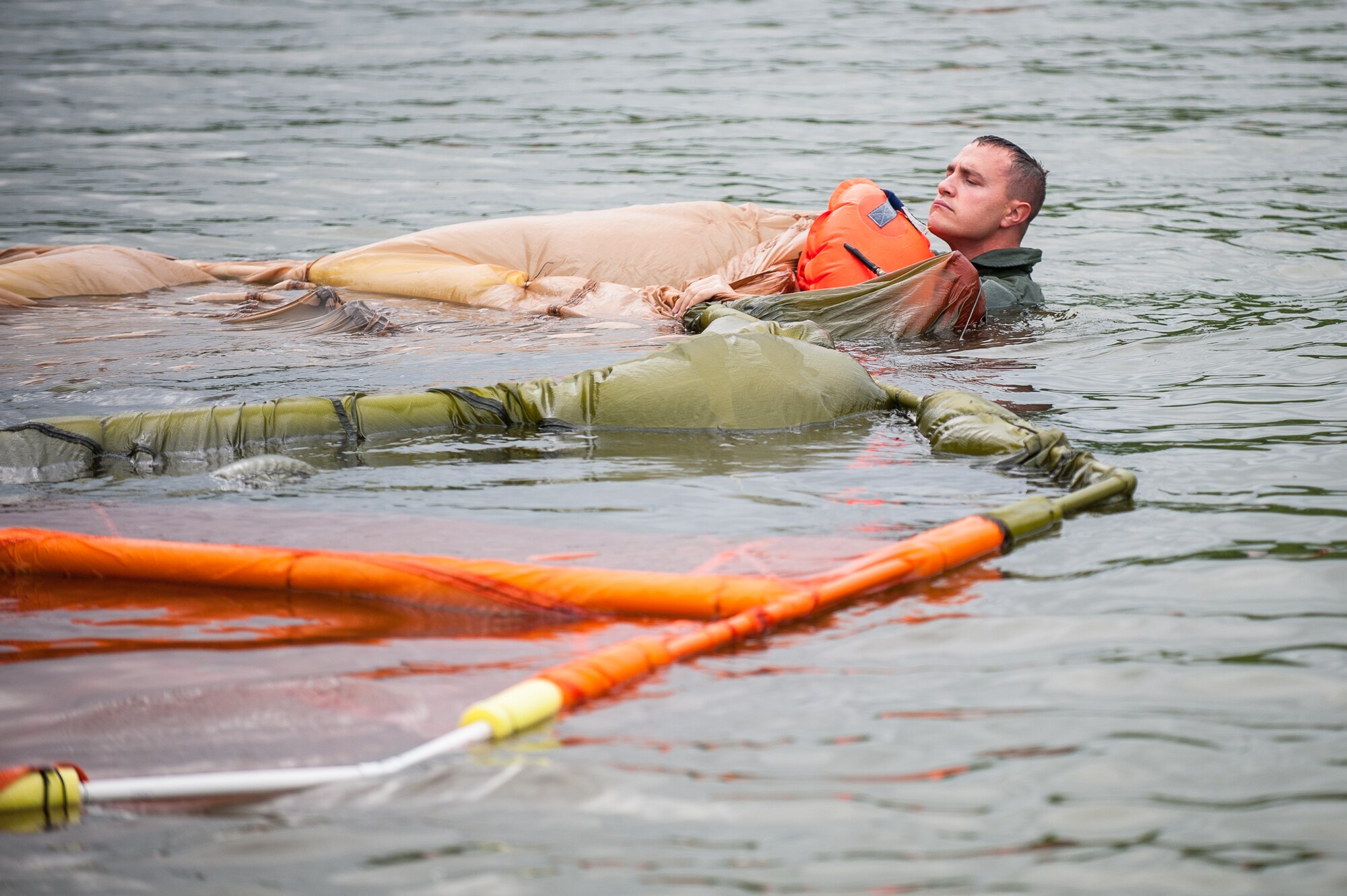 Tech. Sgt. Jerry Passafiume, a loadmaster in the Kentucky Air National Guard’s 165th Airlift Squadron, extricates himself from underneath a floating parachute during water survival training at Taylorsville Lake in Taylorsville, Ky., on June 5, 2014. The training also covered land survival techniques and orienteering. (U.S. Air National Guard photo by Maj. Dale Greer)