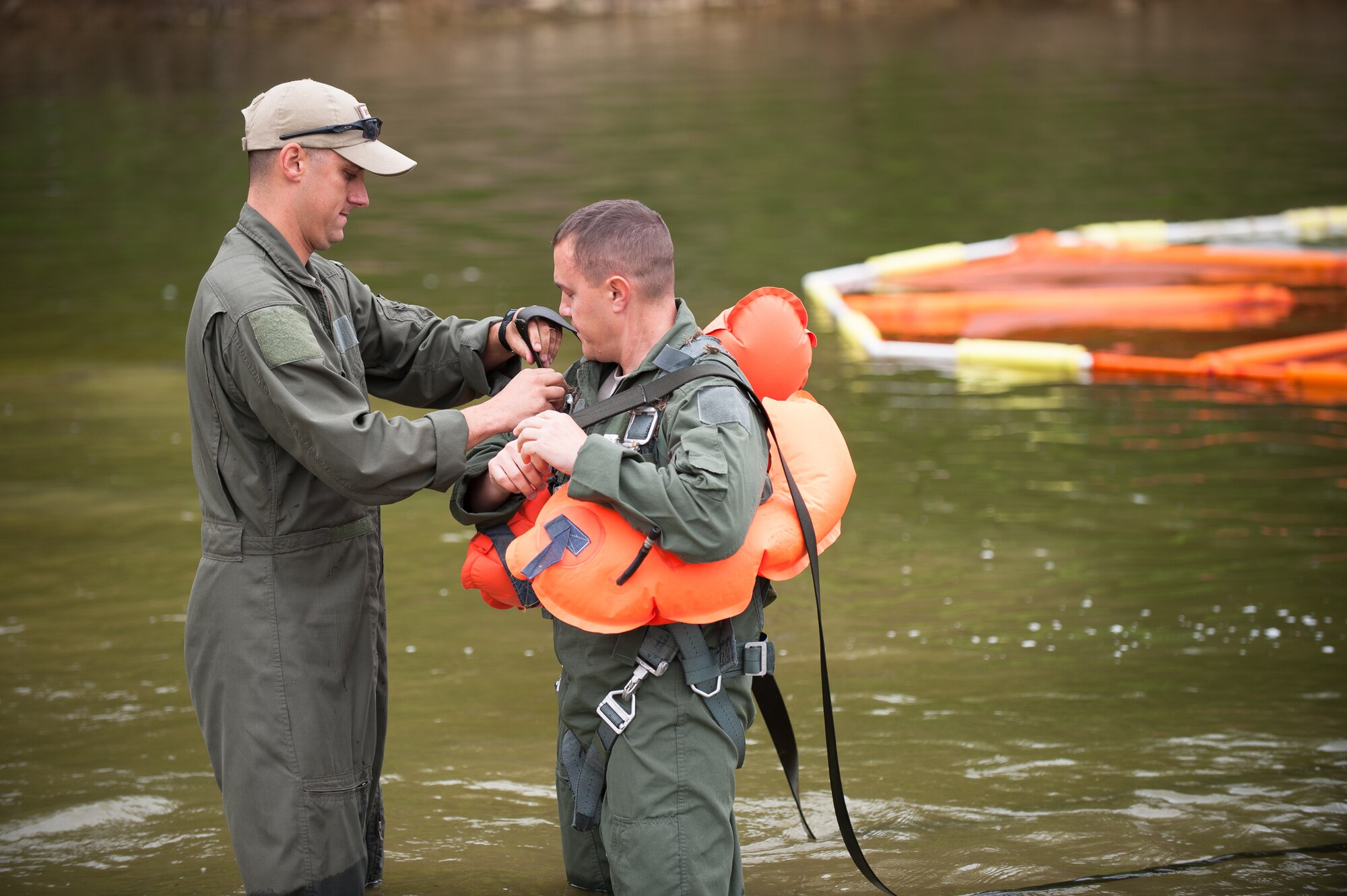 Master Sgt. Brad Simms (left), a loadmaster in the Kentucky Air National Guard’s 165th Airlift Squadron, helps fellow loadmaster Tech. Sgt. Jerry Passafiume strap on a parachute harness prior to water survival training at Taylorsville Lake in Taylorsville, Ky., on June 5, 2014. The training also covered land survival techniques and orienteering. (U.S. Air National Guard photo by Maj. Dale Greer)