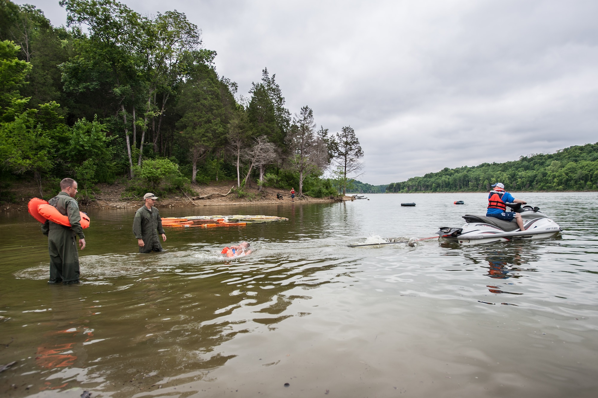 Tech. Sgt. David Clark, an aircrew flight equipment specialist from the Kentucky Air National Guard, pulls Capt. Nick James across Taylorsville Lake in Taylorsville, Ky., using a personal watercraft June 5, 2014, as part of routine survival training. James, a pilot in the 165th Airlift Squadron, is attached to the watercraft by parachute straps and must release the straps to free himself. The exercise is designed to simulate what could happen to aircrew members who’ve parachuted into water when the wind catches their open chutes and drags them across the surface, posing the risk of drowning. (U.S. Air National Guard photo by Maj. Dale Greer)