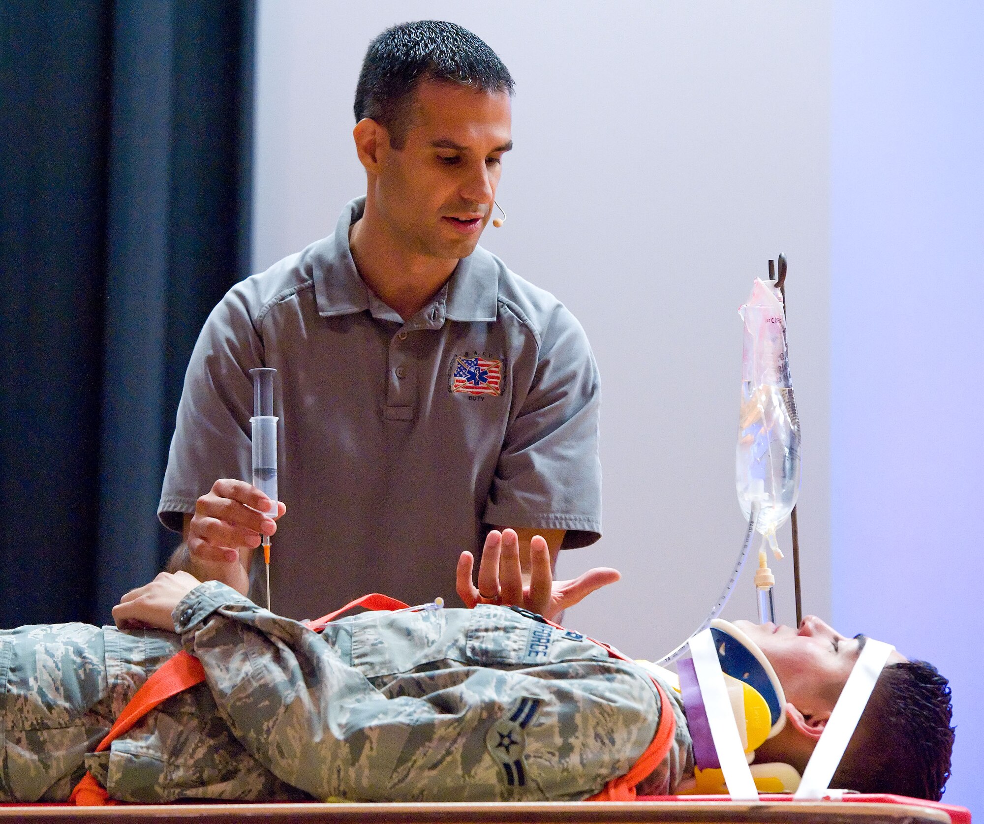 Oscar Duran, left, Street Smart program team member, talks to Airman 1st Class Jon Martinez, right, 436th Aerial Port Squadron cargo processor, June 27, 2014, at the Base Theater on Dover Air Force Base, Del. Duran explained to Martinez the necessity to insert a needle in his abdomen as a result of traumatic injuries he sustained during a simulated vehicle accident. (U.S. Air Force photo/Roland Balik)