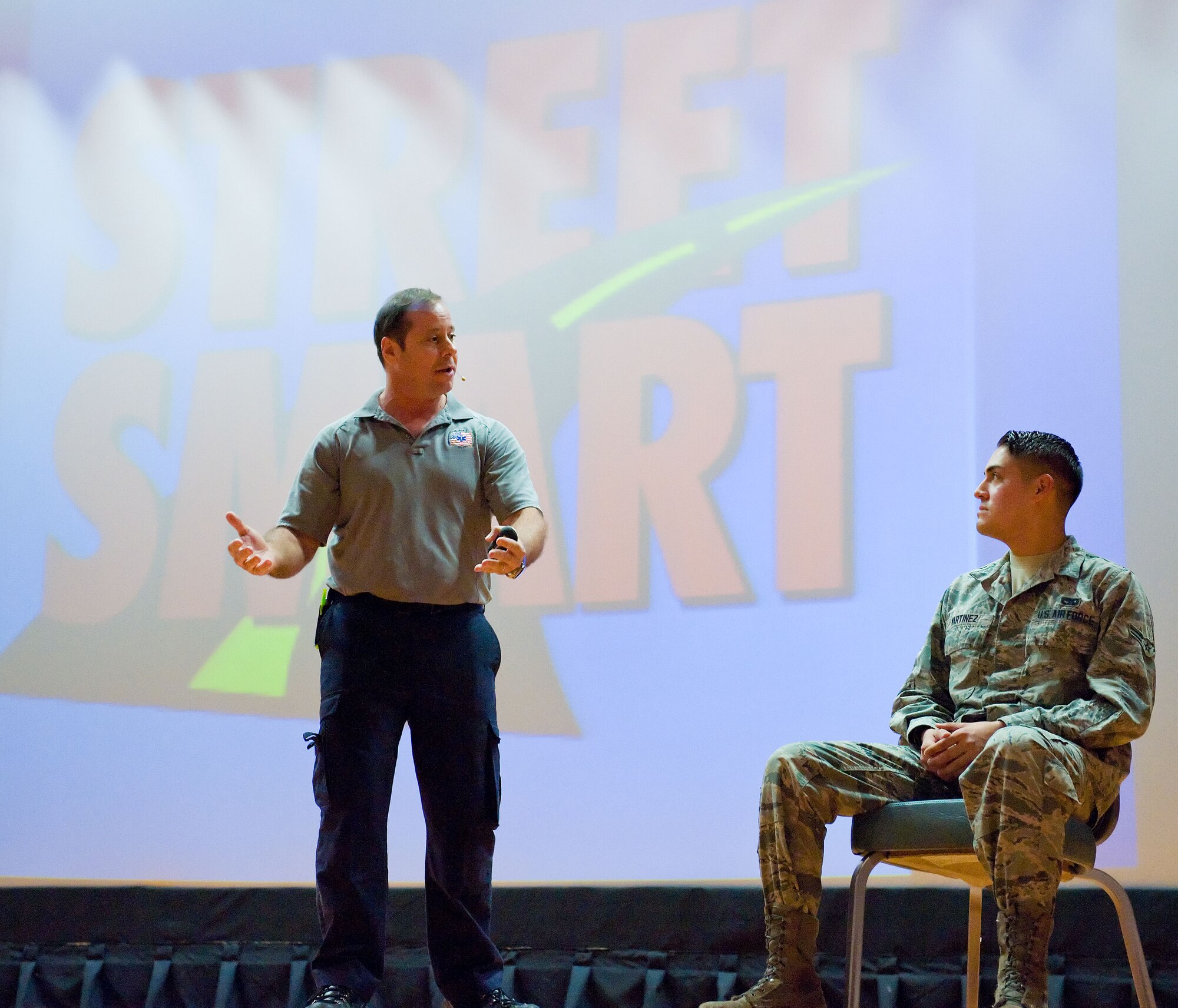 Ralph Jimenez, left, Street Smart program team member, talks to Airman 1st Class Jon Martinez, right, 436th Aerial Port Squadron cargo processor, June 27, 2014, at the Base Theater on Dover Air Force Base, Del. Martinez played the role of an distracted, impaired and injured driver during a scenario orchestrated by Jimenez. The purpose of the Street Smart program is to educate personnel on the consequences of drinking and driving, making poor choices, seatbelt usage and more. (U.S. Air Force photo/Roland Balik)