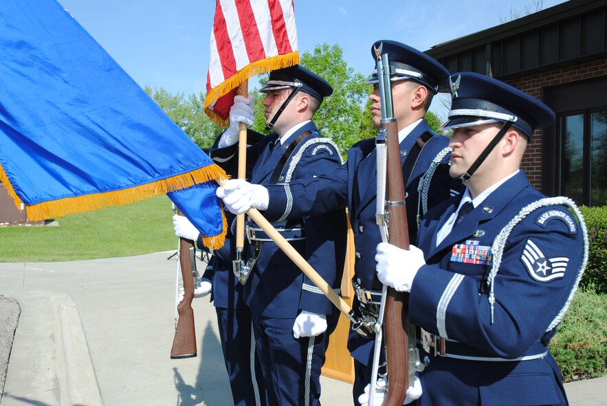 With the U.S. flag stoically in his grasp, Senior Airman Jeffrey Lowder leads a detail from the Grand Forks Air Force Base Honor Guard as they present the colors during the building dedication ceremony for the Chief Master Sgt. Richard L. Etchberger Airman Leadership School held June 4, 2014, on Grand Forks AFB, N.D.  Lowder assists with Honor Guard details on special occasions in addition to working as a financial analysis supervisor for the 319th Comptroller Squadron. (U.S. Air Force photo/Staff Sgt. Luis Loza Gutierrez)
