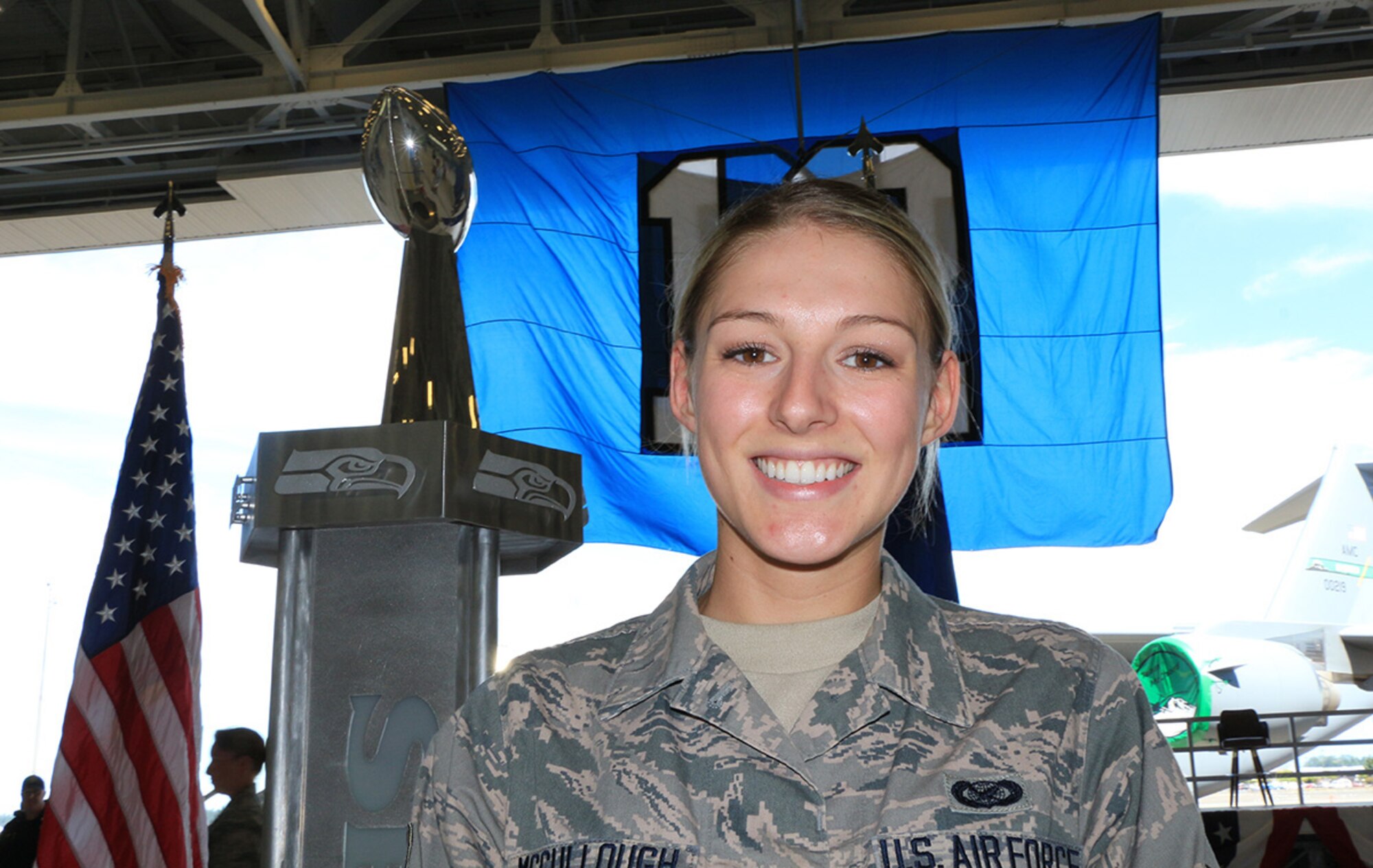 Senior Madelyn McCullough, 446th Airlift Wing, poses by the Lombardi Trophy won by the Seattle Seahawks in the 2013 NFL Super Bowl, at the Heroes of 12 tour event July 1 at Joint Base Lewis-McChord, Washington. (U.S. Air Force Reserve photo by Jake Chappelle)
