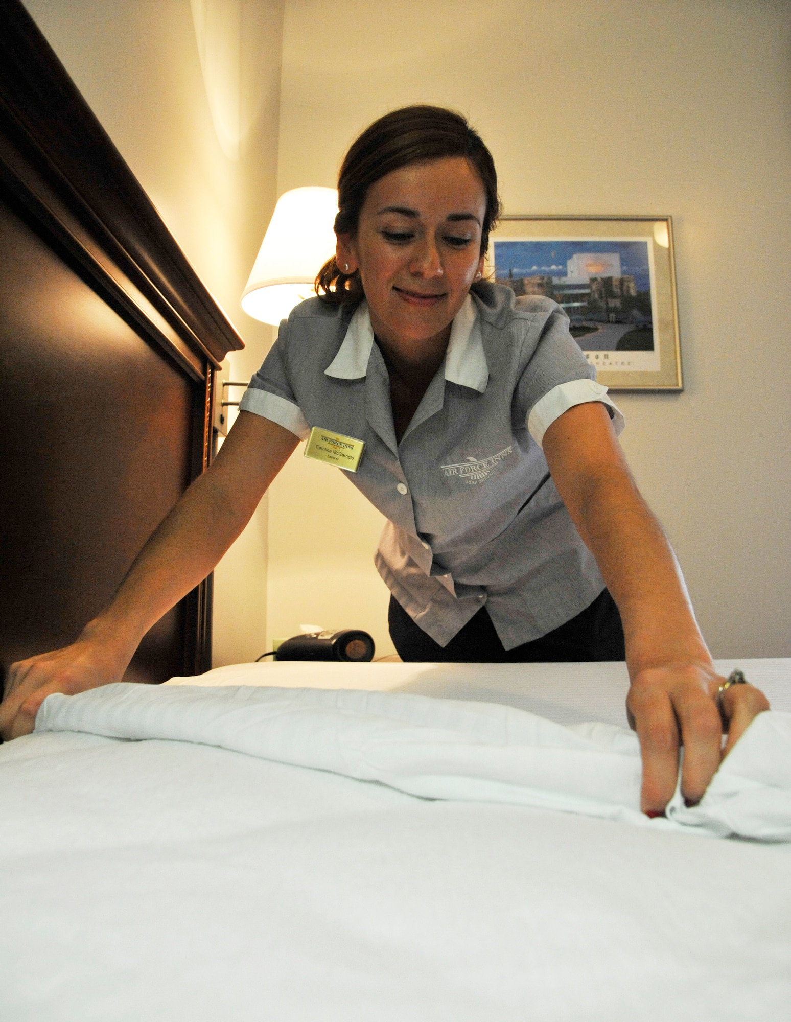 Carolina McGarrigle, 509th Force Support Squadron housekeeper, makes a bed at Whiteman Air Force Base, Mo., June 25, 2014. Preparing rooms are essential to providing presentable living areas for guests. (U.S. Air Force photo by Airman 1st Class Keenan Berry/Released)