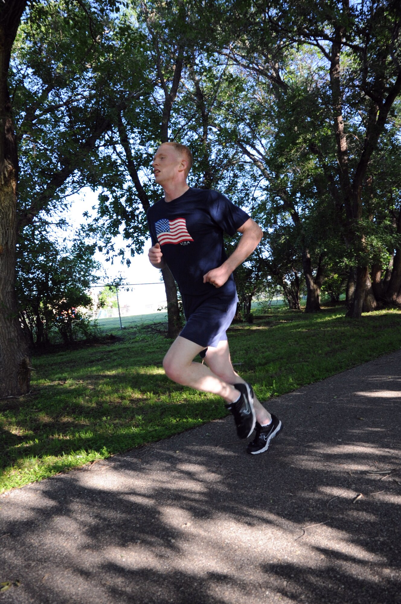 2nd Lt. Brian Peterson runs down the home stretch during the Independence 5K on Grand Forks Air Force Base, N.D., July 2, 2014. Peterson was the first male to finish, with a time of 20 minutes, 11 seconds. (U.S. Air Force photo/Staff Sgt. David Dobrydney)