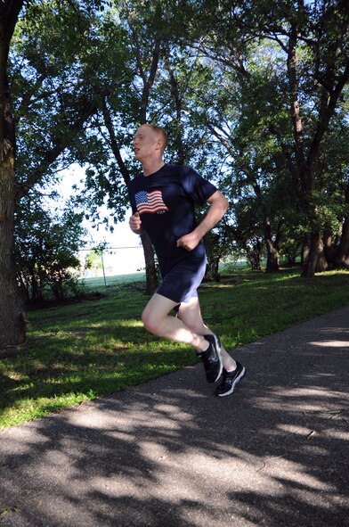 2nd Lt. Brian Peterson runs down the home stretch during the Independence 5K on Grand Forks Air Force Base, N.D., July 2, 2014. Peterson was the first male to finish, with a time of 20 minutes, 11 seconds. (U.S. Air Force photo/Staff Sgt. David Dobrydney)