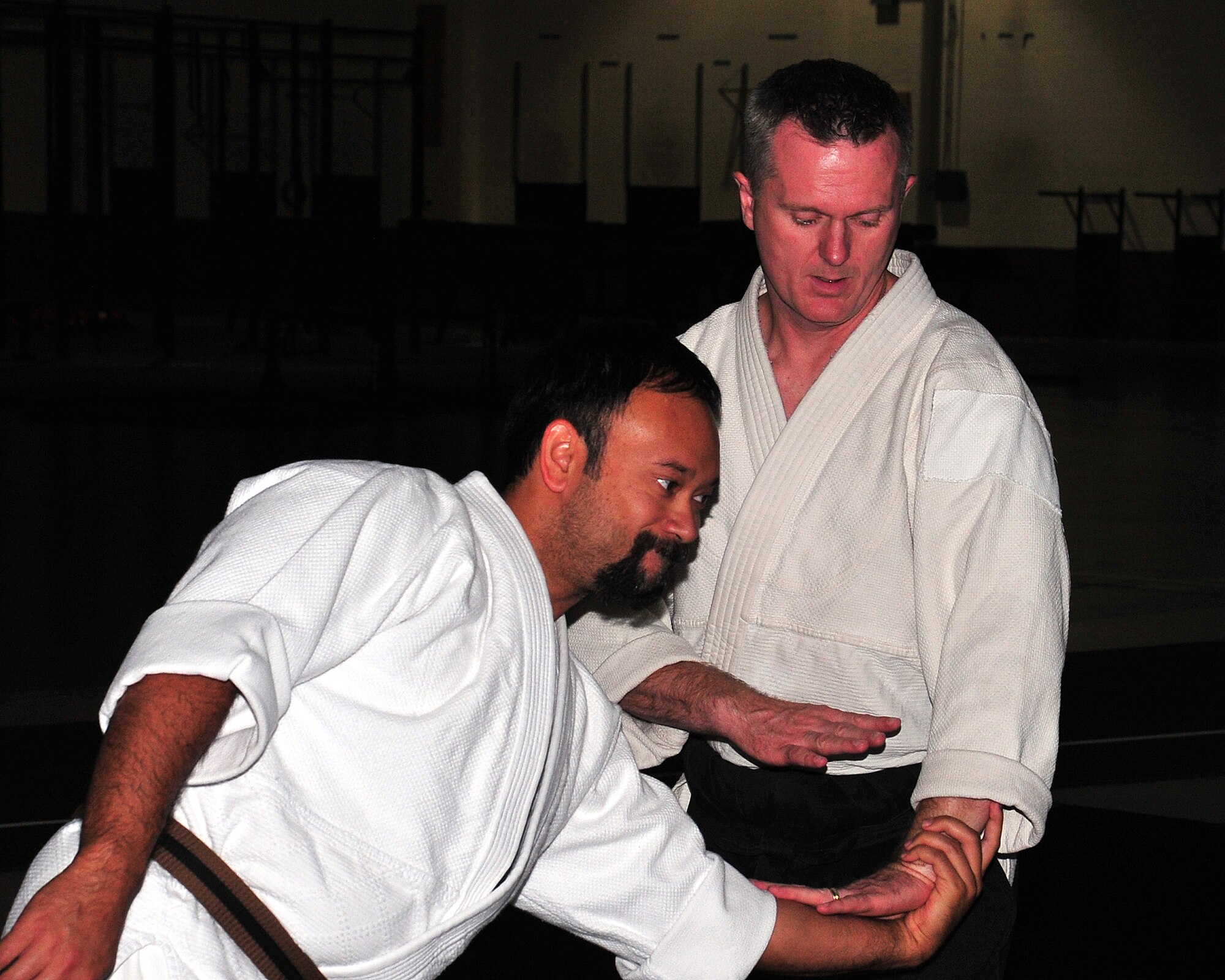 U.S. Navy Reserve Lt. Cmdr. Lloyd McWhirt demonstrates an Aikido joint-locking technique on his assistant, Brad Clear, May 22 at the field house on Offutt Air Force Base, Nebraska. McWhirt runs his own Dojo in downtown Omaha and gives free Aikido lessons to the Offutt community at the Offutt Field House. (U.S. Air Force photo by D.P. Heard/Released)