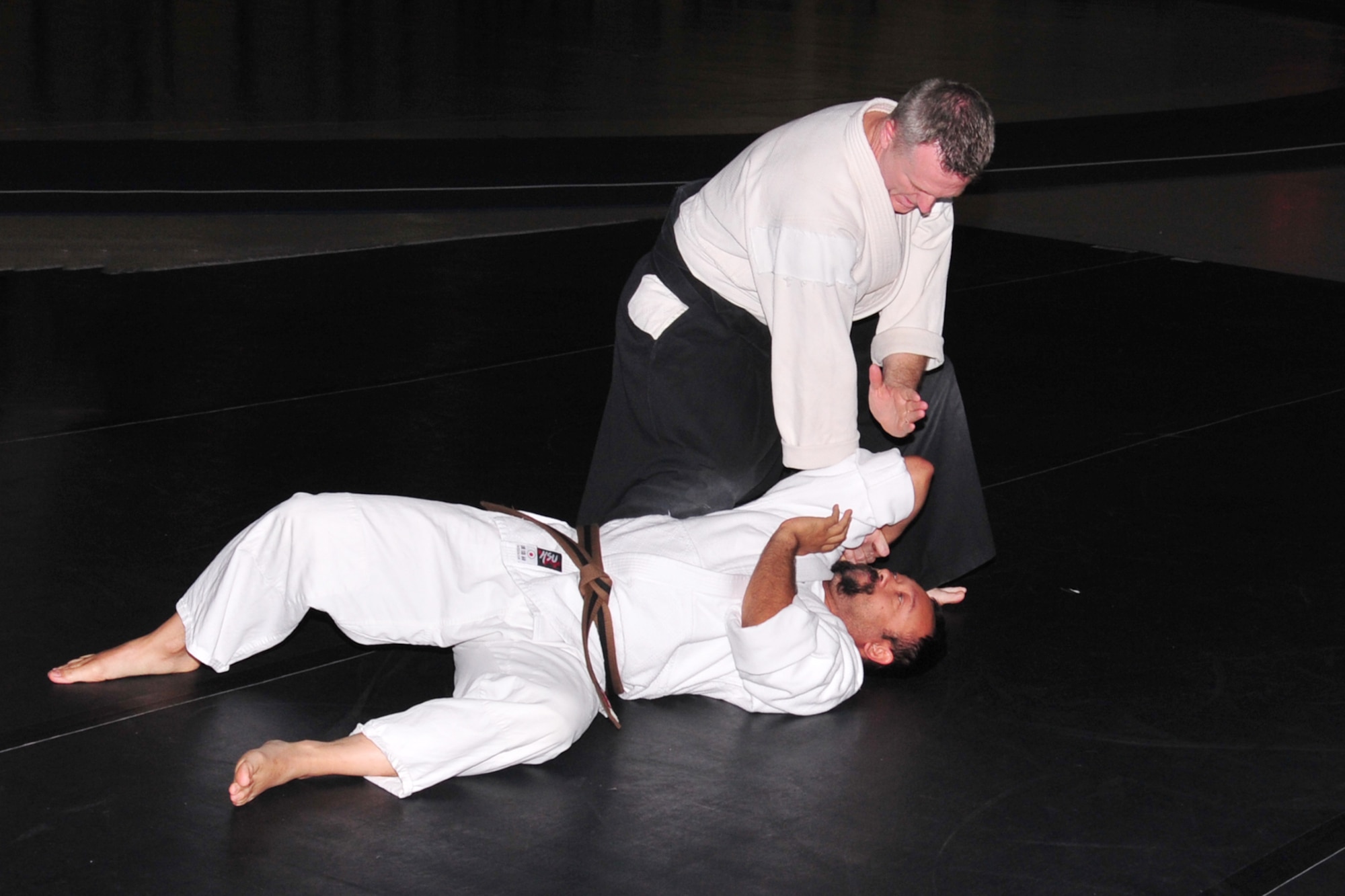 U.S. Navy Reserve Lt. Cmdr. Lloyd McWhirt demonstrates an Akido throwing technique on his assistant, Brad Clear, May 22 at the field house on Offutt Air Force Base, Nebraska. McWhirt runs his own Dojo in downtown Omaha and gives free Aikido lessons to the Offutt community at the Offutt Field House. (U.S. Air Force photo by D.P. Heard/Released)