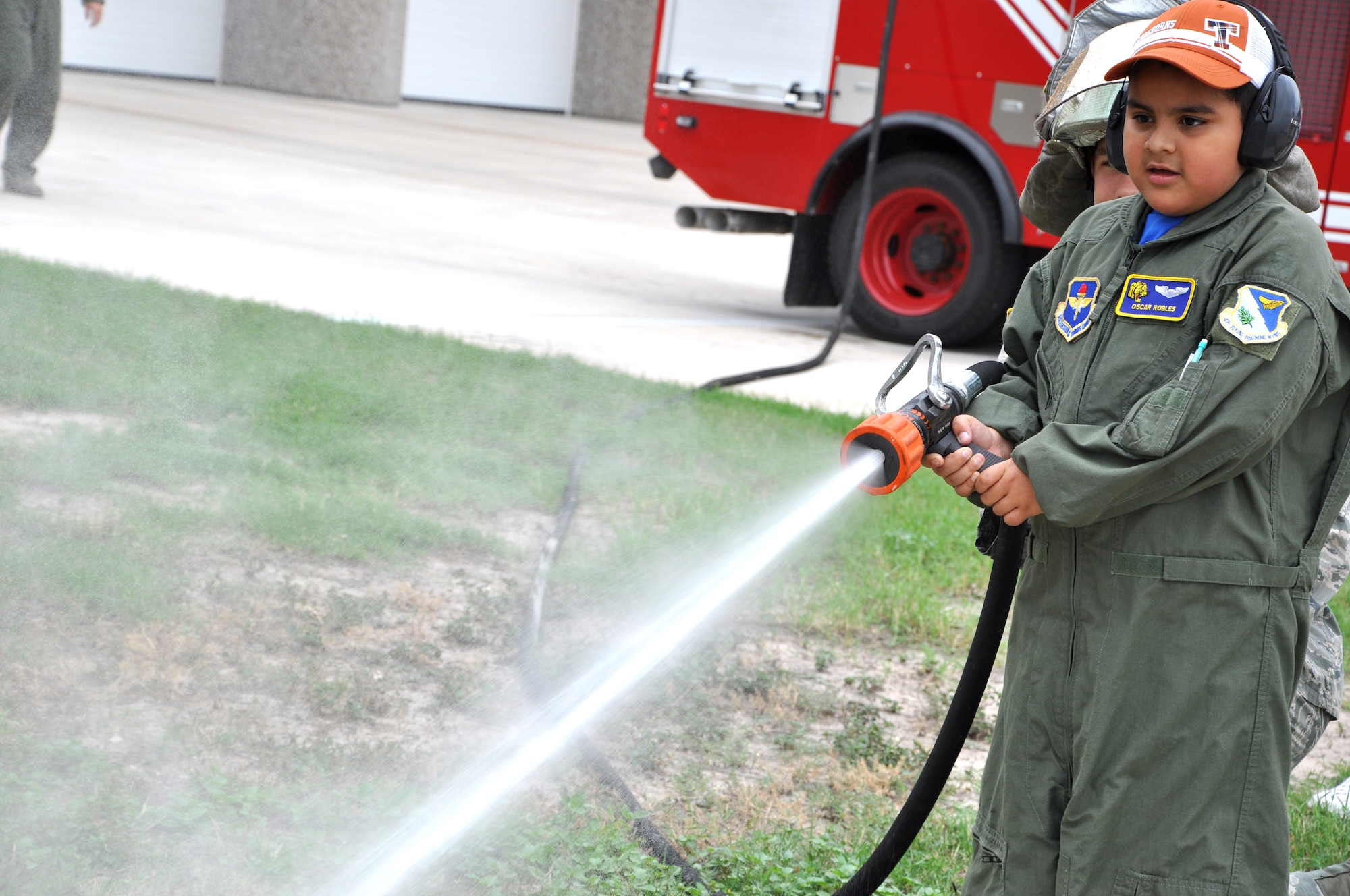 Oscar Robles, Laughlin’s honorary pilot for a day, uses a fire hose during a tour of Laughlin Air Force Base, Texas, June 27, 2014. As pilot for the day, Oscar was taken for a tour around the base to see demonstrations by the fire station and security forces. (U.S. Air Force photo by Airman 1st Class Ariel D. Delgado)(Released)