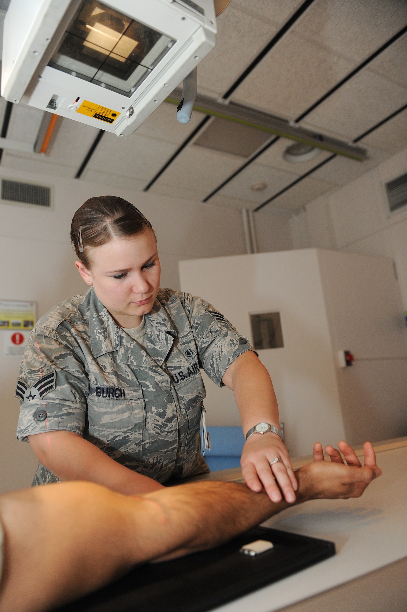Senior Airman Casey Burch positions a patient for an anterior to posterior elbow X-ray at Scott Air Force Base, Ill., June 3, 2014.  Burch said she really tries to make her patients feel as comfortable as possible during the exam, even if it is an uncomfortable procedure.  Burch is a 375th Medical Support Squadron radiology technologist.  (U.S. Air Force photo by Staff Sgt. Maria Bowman)