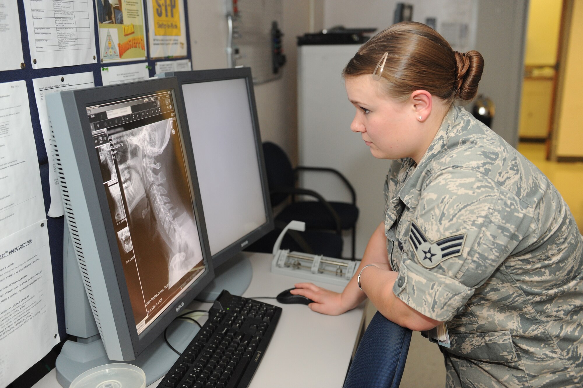 Senior Airman Casey Burch looks at a patient’s X-ray at Scott Air Force Base, Ill., June 3, 2014.  This process is called Quality Control, where X-ray images are double checked in order to make sure radiographs are correct and of a diagnostic quality.  Burch is a 375th Medical Support Squadron radiology technologist.  (U.S. Air Force photo by Staff Sgt. Maria Bowman)