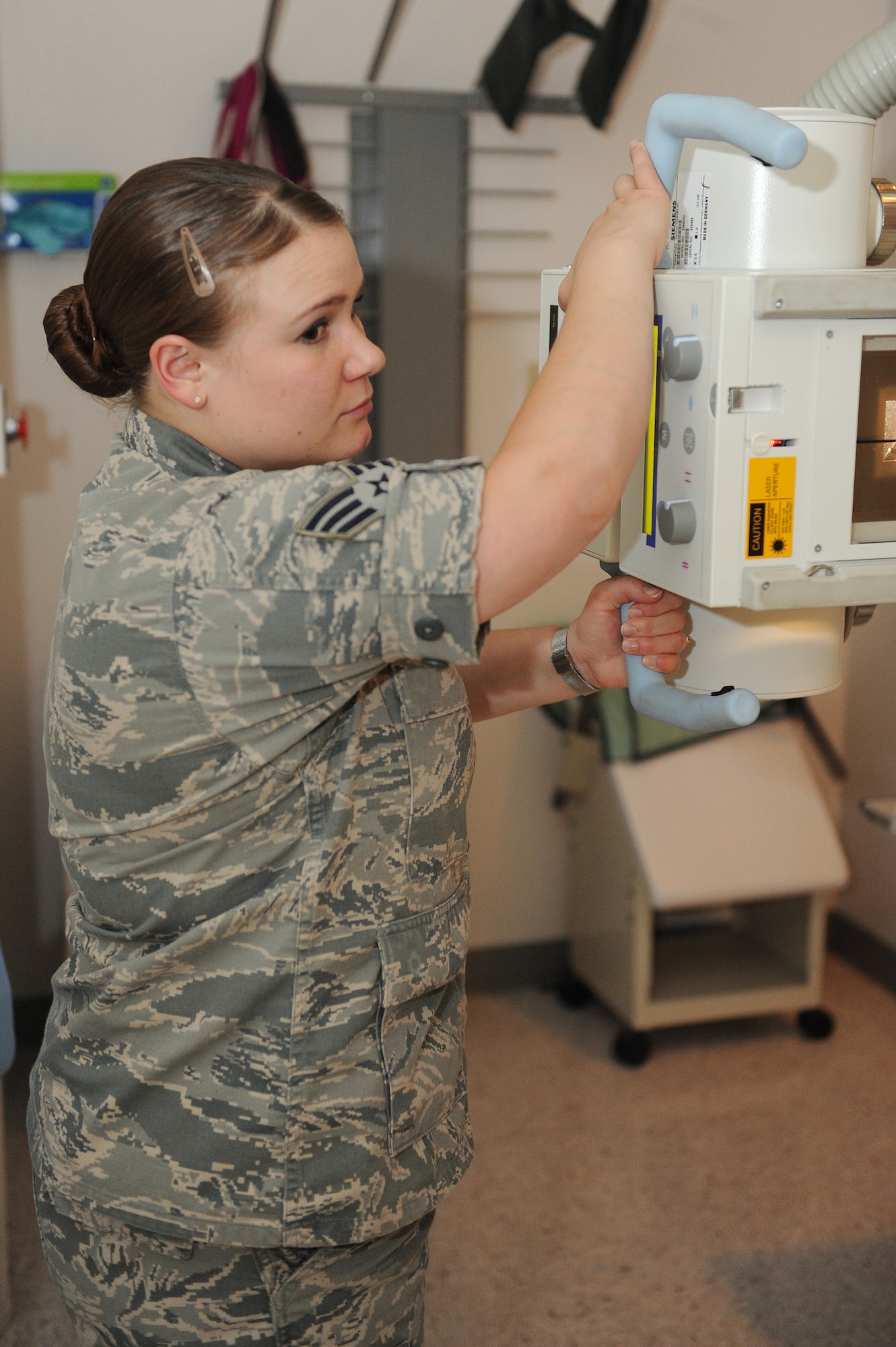 Senior Airman Casey Burch lines up an X-ray tube at Scott Air Force Base, Ill., June 3, 2014.  The tube moves up and down to coincide with a patient’s anatomy for each specific exam, including chest X-rays.  Burch is a 375th Medical Support Squadron radiology technologist.  (U.S. Air Force photo by Staff Sgt. Maria Bowman)