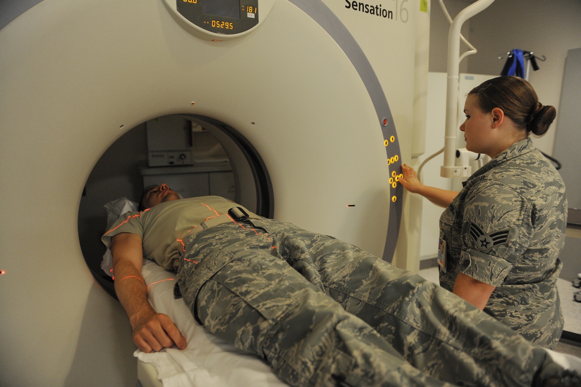 Senior Airman Casey Burch lines a patient up to a CT scanner at Scott Air Force Base, Ill., June 3, 2014.  A CT scan is a high-tech medical test that helps a radiologist diagnose different types of diseases.  Burch is a 375th Medical Support Squadron radiology technologist.  (U.S. Air Force photo by Staff Sgt. Maria Bowman)