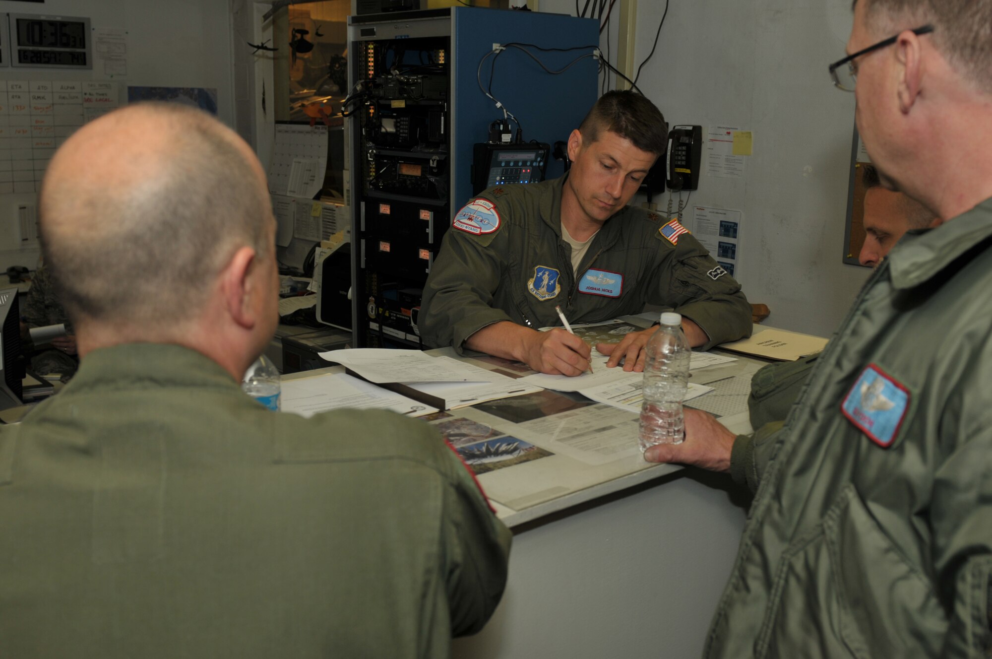 Maj. Joshua Hicks, deployed commander for the most recent Greenland rotation, goes over flight planning with aircrew members at Kangerlussuaq, Greenland on June 28, 2014. Two LC-130s and 70 Airmen from the Wing recently completed the fourth rotation of the 2014 Greenland season. The unit flies supply and refueling missions to various camps in support of the National Science Foundation and also trains for the Operation Deep Freeze mission in Antarctica. (U.S. Air National Guard photo by Master Sgt. William Gizara)