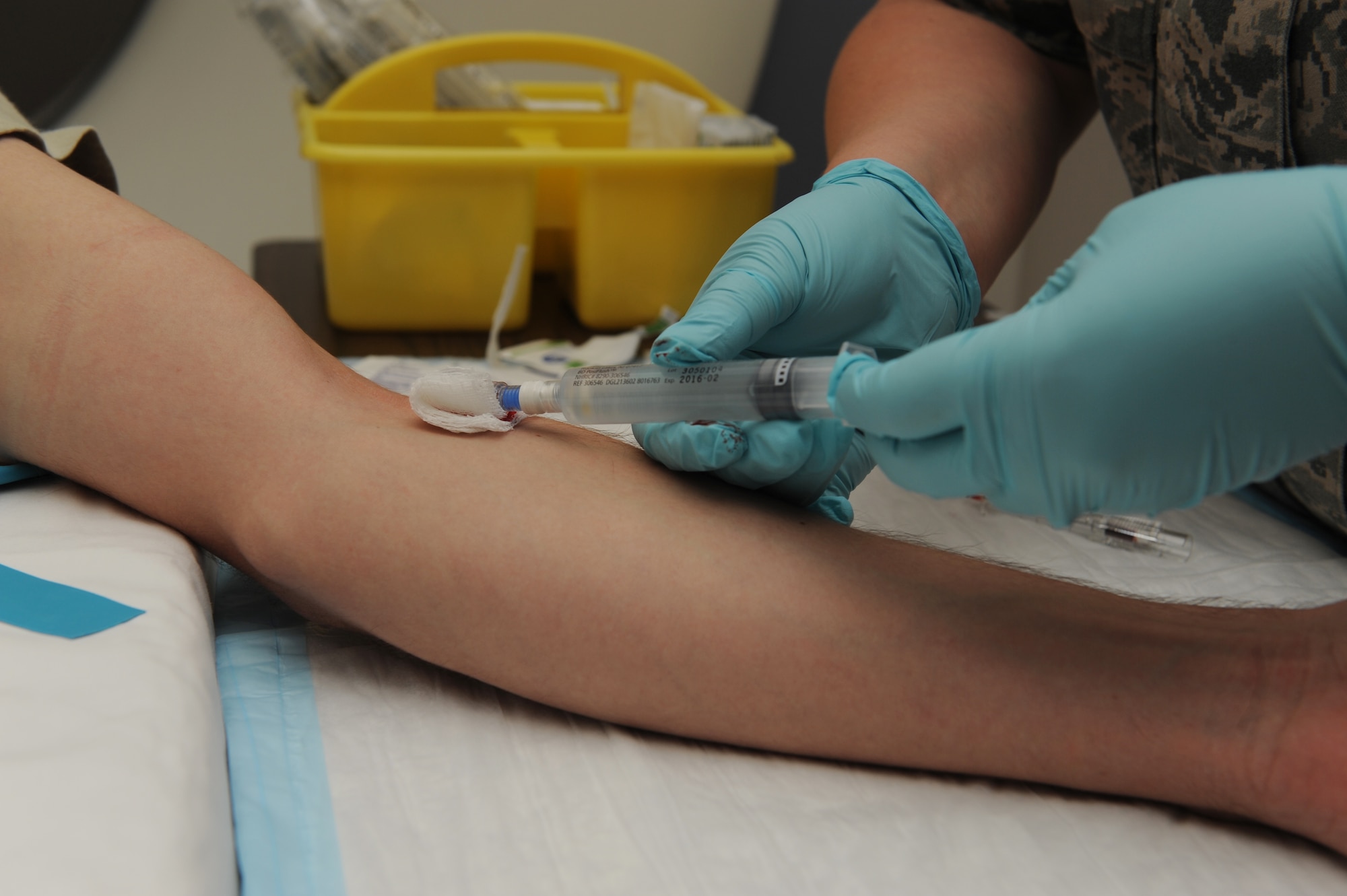Senior Airman Casey Burch inserts an IV into a patient before going into the CT scan at Scott Air Force Base, Ill., June 3, 2014.  To ensure the IV is inserted properly, Burch checks for flashback, or blood in the tube.  If there is flashback, the catheter can be advanced.  The IV delivers contrast into the patient’s veins in order to highlight certain areas on the body when it is scanned, which makes it easier for the radiologist to see.  Burch is a 375th Medical Support Squadron radiology technologist.  (U.S. Air Force photo by Staff Sgt. Maria Bowman)