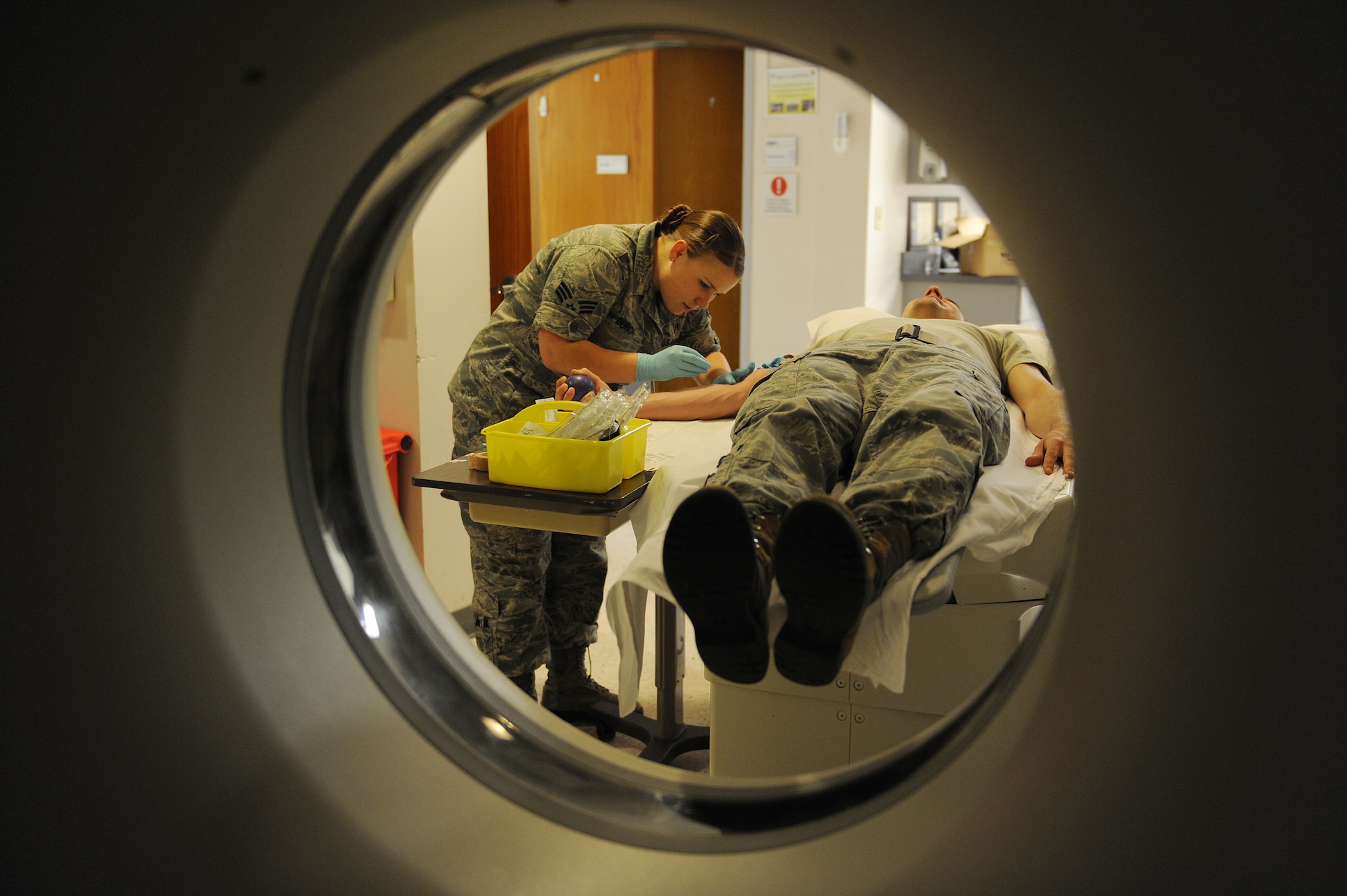 Senior Airman Casey Burch prepares to insert an IV into a patient before going into the CT scan at Scott Air Force Base, Ill., June 3, 2014.  The IV delivers the contrast into the patient’s veins in order to highlight certain areas on the body when it is scanned, which makes it easier for the radiologist to see.  Burch is a 375th Medical Support Squadron radiology technologist.  (U.S. Air Force photo by Staff Sgt. Maria Bowman) by Staff Sgt. Maria Bowman)