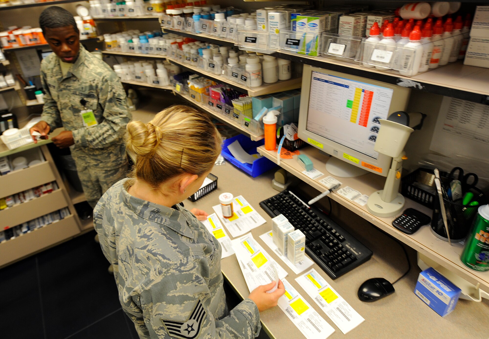 Staff Sgt. Tracy Duncan, 1st Special Operations Medical Operations Squadron narcotics vault custodian, and Airman 1st Class Donovan Washington, 1st SOMOS pharmacy technician, label and store medication at the pharmacy on Hurlburt Field, Fla., May 30, 2014. The unit promotes and maintains 8,900 active-duty members’ health. (U.S. Air Force photo/Airman 1st Class Andrea Posey)