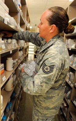 Tech. Sgt. Audrey York, 1st Special Operations Medical Operations Squadron medical logistics NCO in charge, places medication onto shelves at the pharmacy on Hurlburt Field, Fla., May 30, 2014. Medication is alphabetically stored on selves until a prescription needs to be filled. (U.S. Air Force photo/Airman 1st Class Andrea Posey)