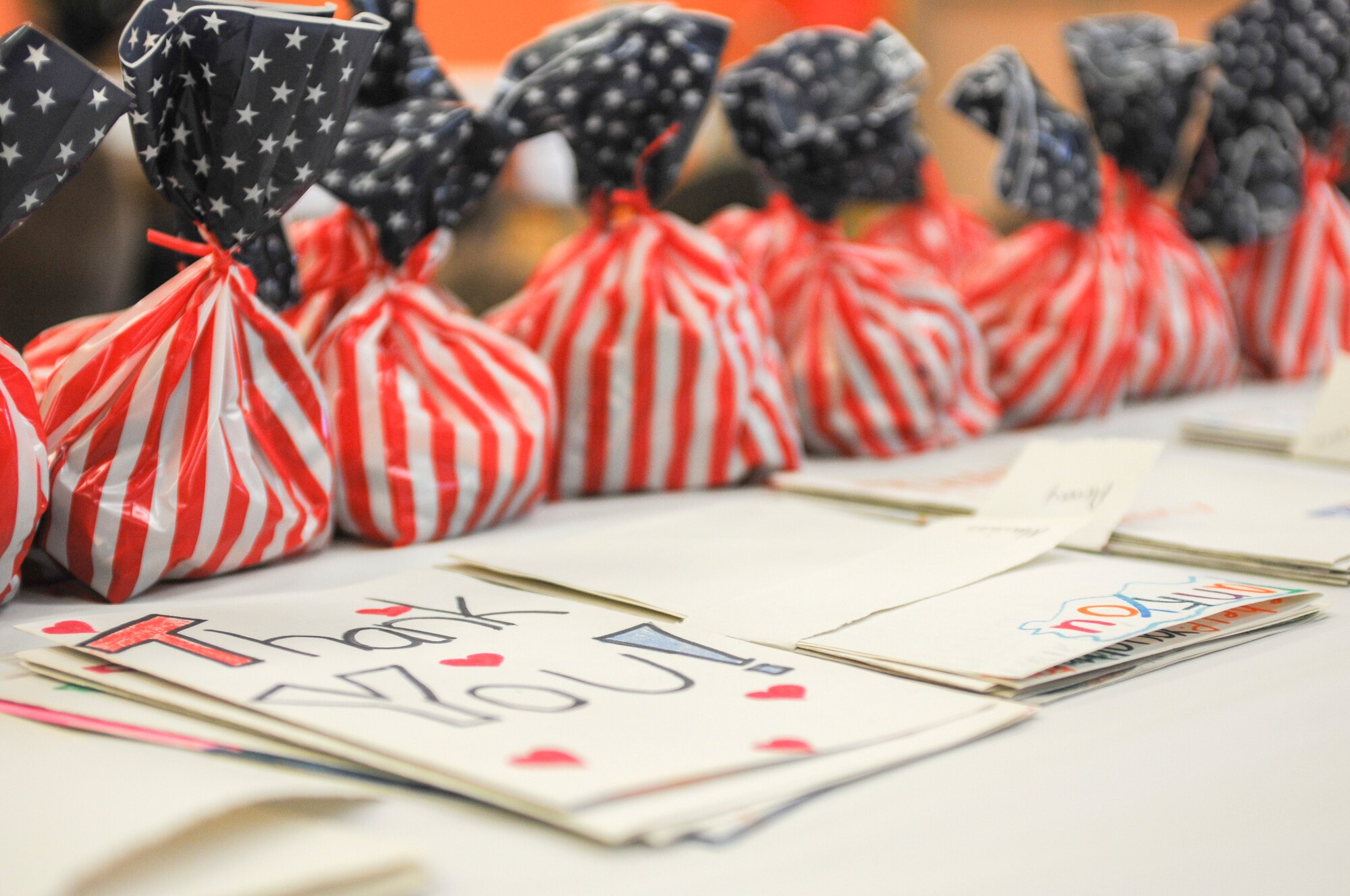 Goodie backs and thank you cards, prepared by students at Kidz by the Riverside daycare in Warren, Ohio, are displayed on a table June 26, 2014. Students at the daycare’s summer program crafted the items to present to public service personnel after learning about various service professions. To receive the gifts and answer questions about their careers, the daycare invited three Airmen, a sailor and a Marine from Youngstown Air Reserve Station, along with two soldiers from Warren’s Army Recruiting Center, a local firefighter and a detective from the Trumbull County Sheriff’s office. U.S. Air Force photo/Eric M. White.