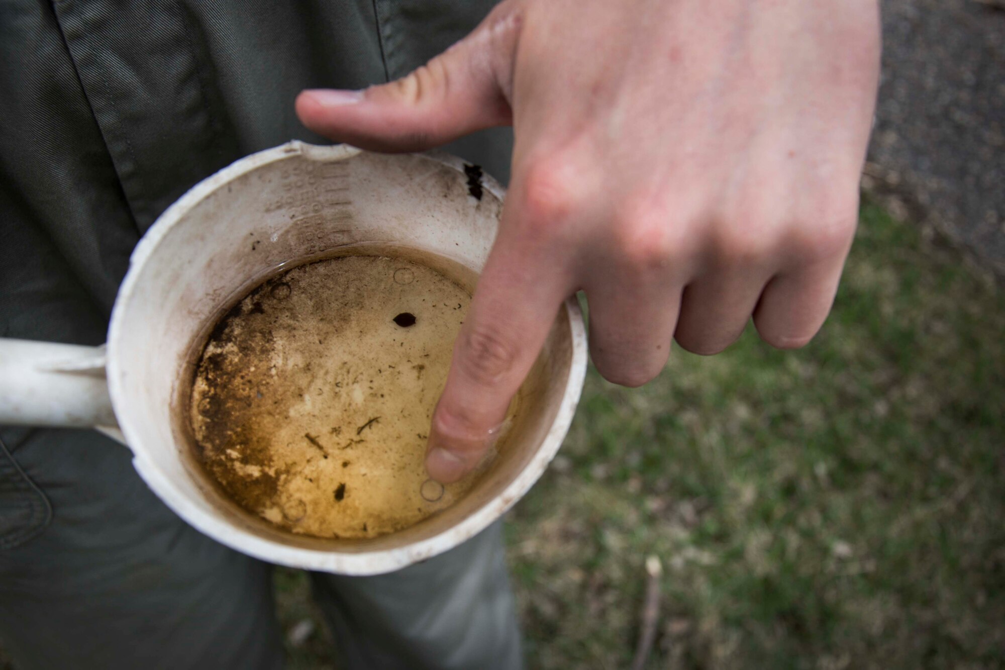 Senior Airman Nathaniel Boober, 5th Civil Engineer Squadron pest control, inspects a sample of standing water taken from the grounds of Minot Air Force Base, May 19, 2014. Tallying the amount of larvae in each area, Boober can take steps to prevent further breeding of the insects on the base. (U.S. Air Force photos/Airman 1st Class Lauren Pitts) 