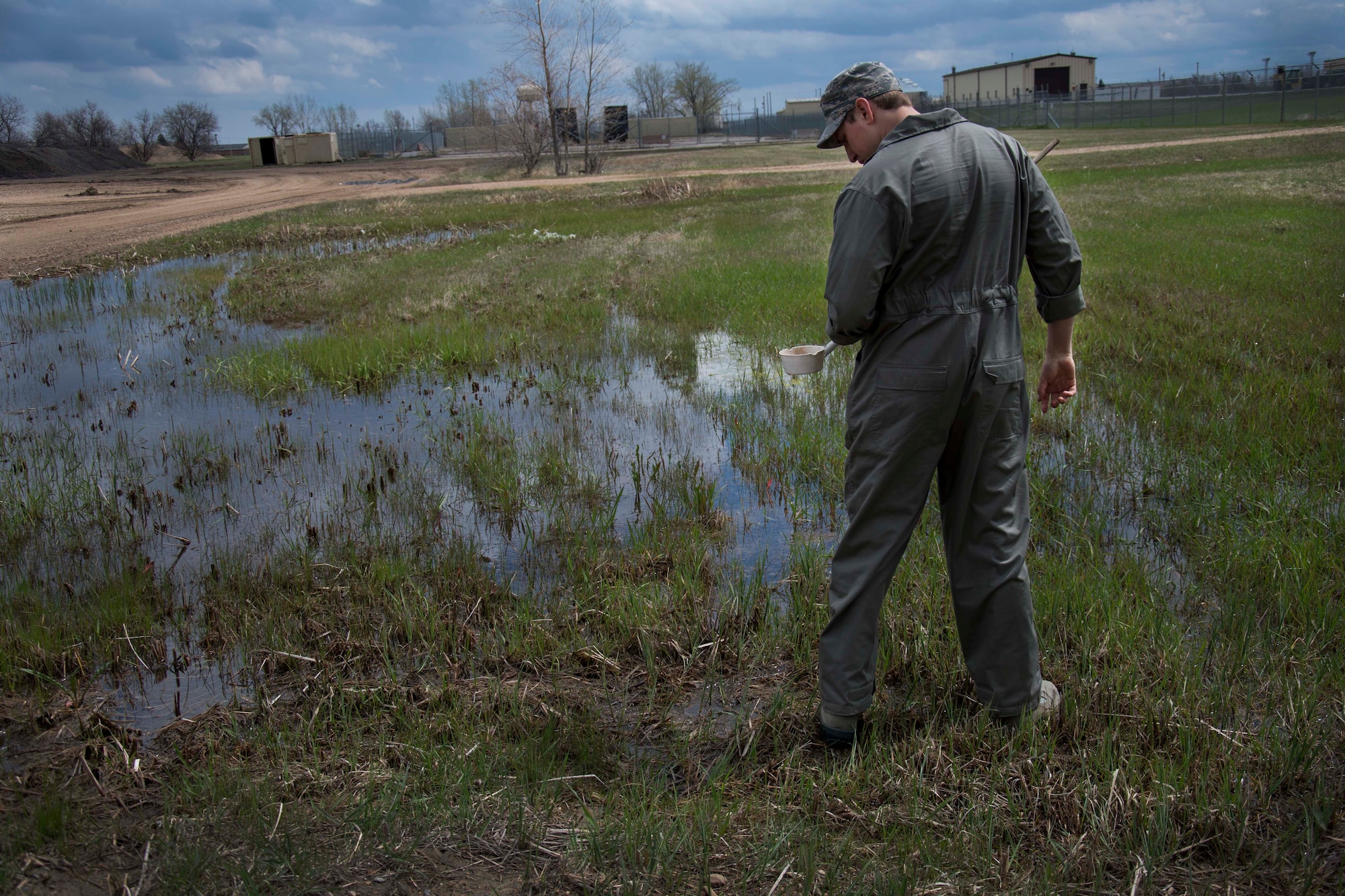Senior Airman Nathaniel Boober, 5th Civil Engineer Squadron insect control, scouts the base for standing water in search of mosquito larvae at Minot Air Force Base, May 19, 2014. By identifying where most of the insects lay their eggs, Boober can more effectively prevent their breeding. (U.S. Air Force photos/Airman 1st Class Lauren Pitts) 