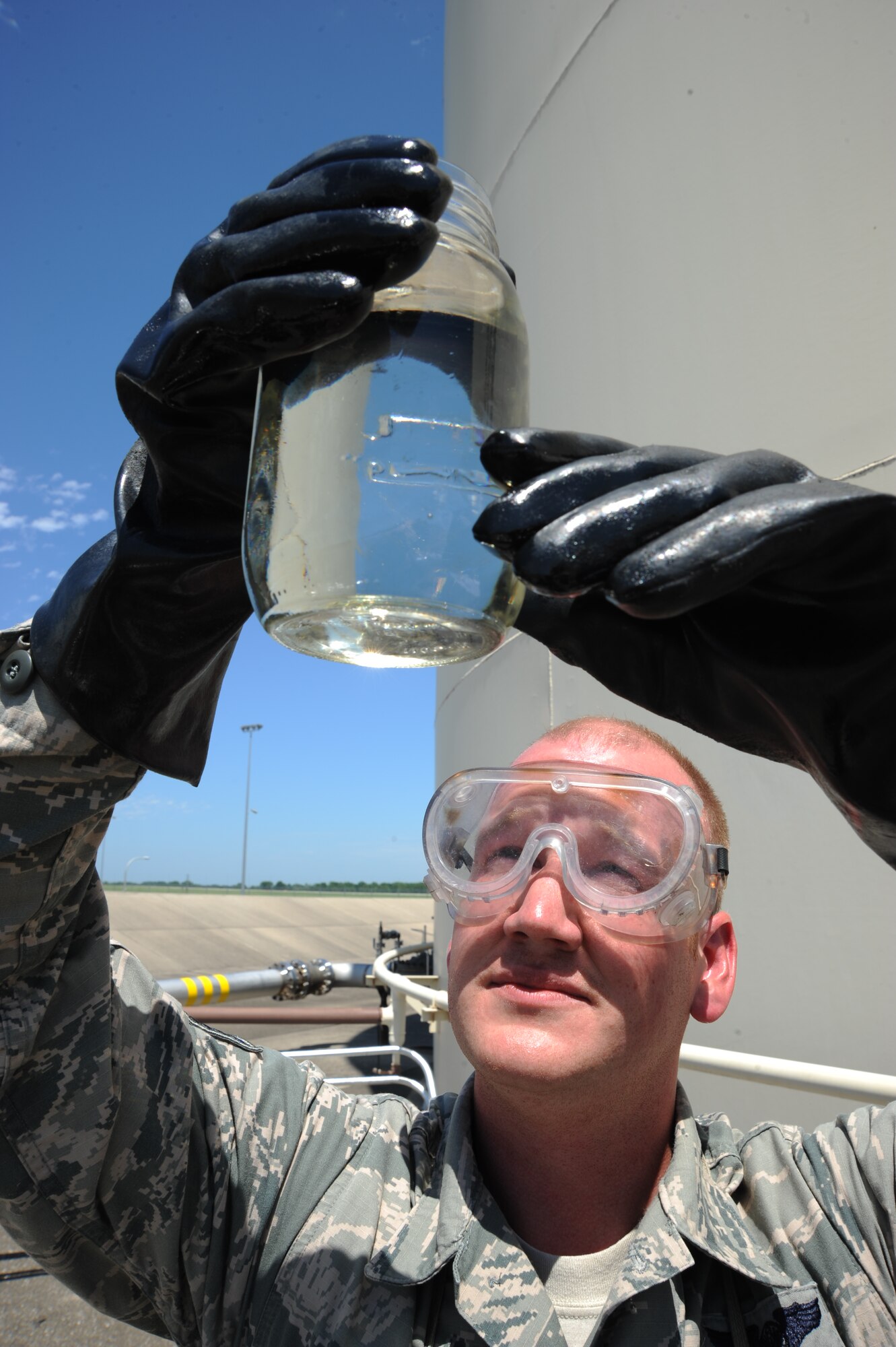 Staff Sgt. Matthew Tidball, 509th Logistics Readiness Squadron fuels hydrants supervisor, inspects a sample of JP-8 Jet Fuel at Whiteman Air Force Base, Mo., July 1, 2014. Before beginning to cross-train Tidball has worked as fuels distribution operator and supervisor, fuels service center technician, fuels accountant and his current job as fuels hydrants supervisor. (U.S. Air Force photo by Senior Airman Bryan Crane/Released)