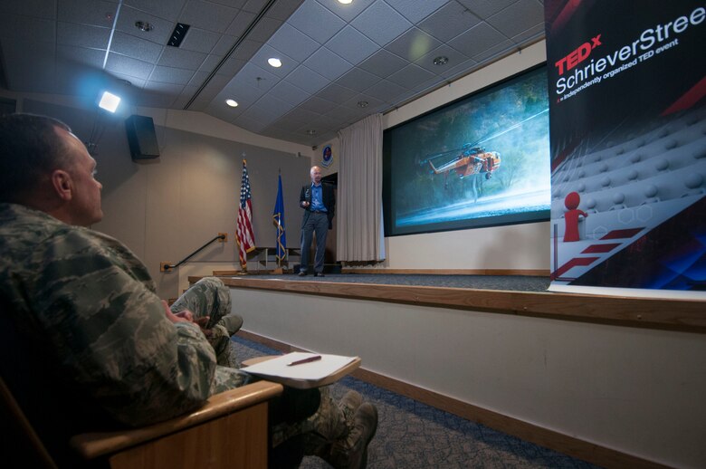 Lt. Col. Jason Sutton, 50th Network Operations Group commander, listens to Kerry Grant, chief scientist for the Joint Polar Satellite System Common Ground System during TEDxSchrieverStreet inside the Building. 300 Auditorium June 20, 2014, Schriever Air Force Base, Colorado. The theme of the event was “limits,” and Grant spoke about how the most pressing limits we set are those to our imagination. (U.S. Air Force photo/Senior Airman Naomi Griego)