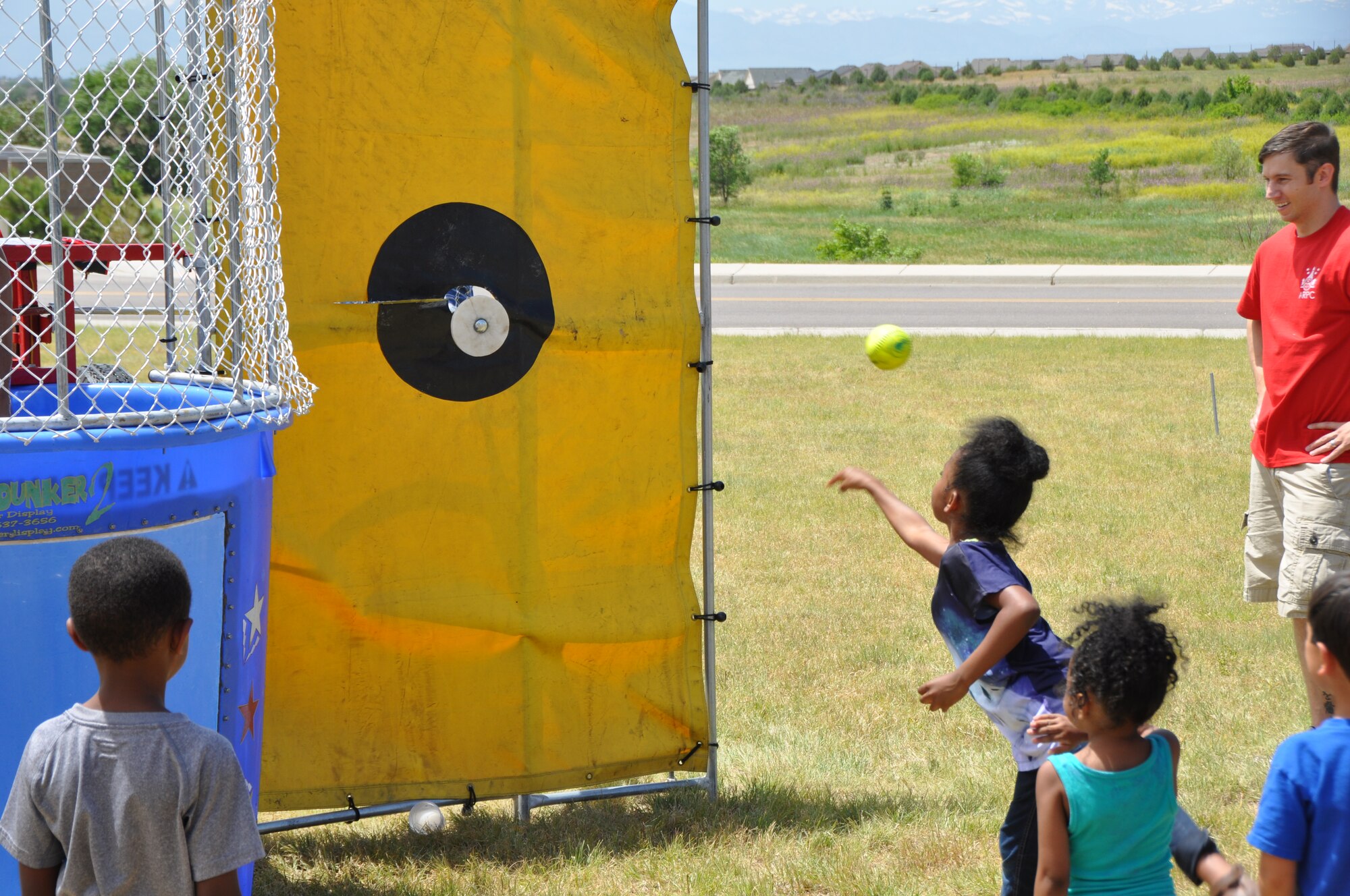 A child throws a softball in her attempt to dunk an Air Reserve Personnel Center service member in the dunk tank during the ARPC commander's fitness and funfest June 30, 2014, at Buckley Air Force Base, Colo. More than 150 service members, civilians and their families attended the event that highlighted the commander’s physical fitness enhancement program’s winning team for the April through June quarter and served as this year's picnic. Activities at the funfest included a 3-kilometer run, dunk tank, a bounce house for children and interactive games including volleyball, bocce ball and horseshoes. (U.S. Air Force photo/Tech. Sgt. Rob Hazelett)