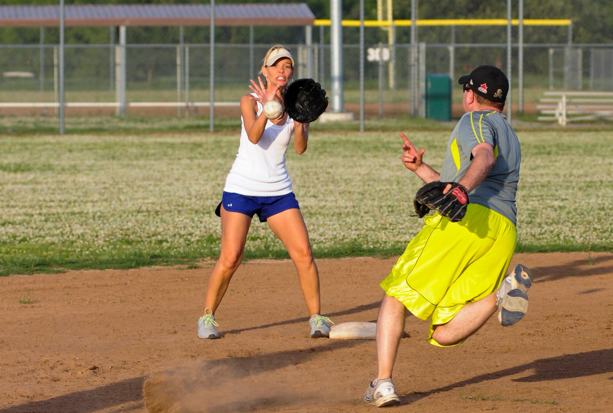 Master Sgt. Chris Shamiyeh flips the ball to Denise Lawson for the force out a second during the Okies 14-0 loss to the Navy's VQ-7 Roughnecks Thursday June 26.  The Okies season got off to a slow start with back-to-back losses to the Roughnecks.  Their next game is slated for July 10.  (U.S. Air Force photo/Senior Airman Mark Hybers)