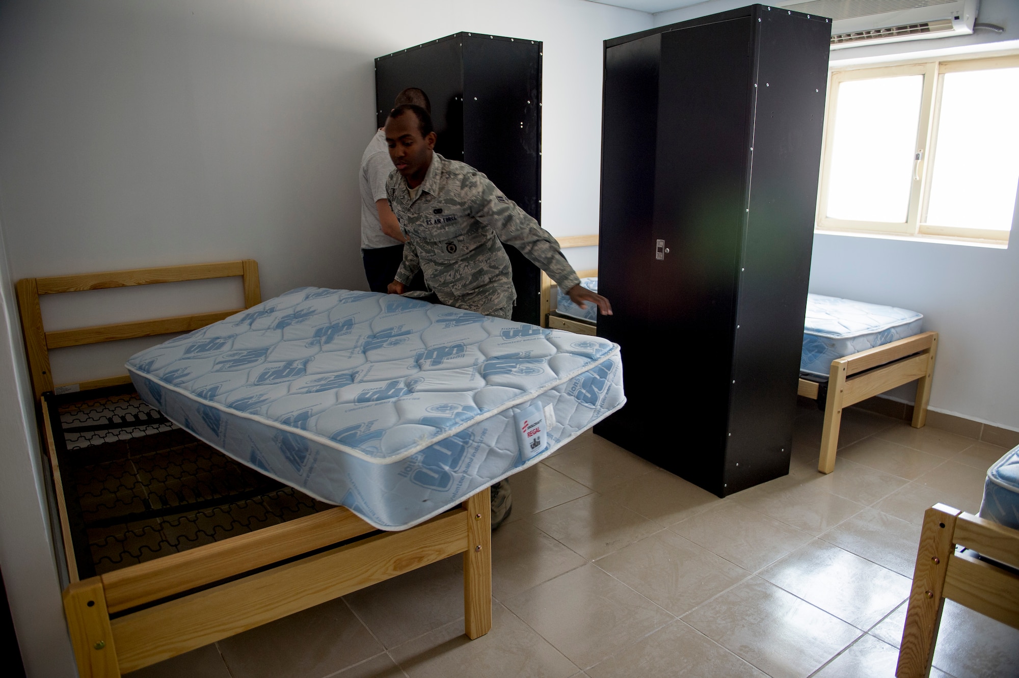 U.S Air Force Airman 1st Class Berket Berhane, 386th Expeditionary Security Forces airbase defense patrolman, lays a new mattress on a bed frame as part of a base dormitory renovation June 12, 2014 at an undisclosed location in Southwest Asia. Berhane is deployed from the 159th Security Forces Squadron, Naval Air Station-Joint Reserve Base New Orleans, Louisiana in support of Operation Enduring Freedom. A total of 23 dorms are scheduled to be renovated by the end of the year. (U.S. Air Force photo by Staff Sgt. Jeremy Bowcock)