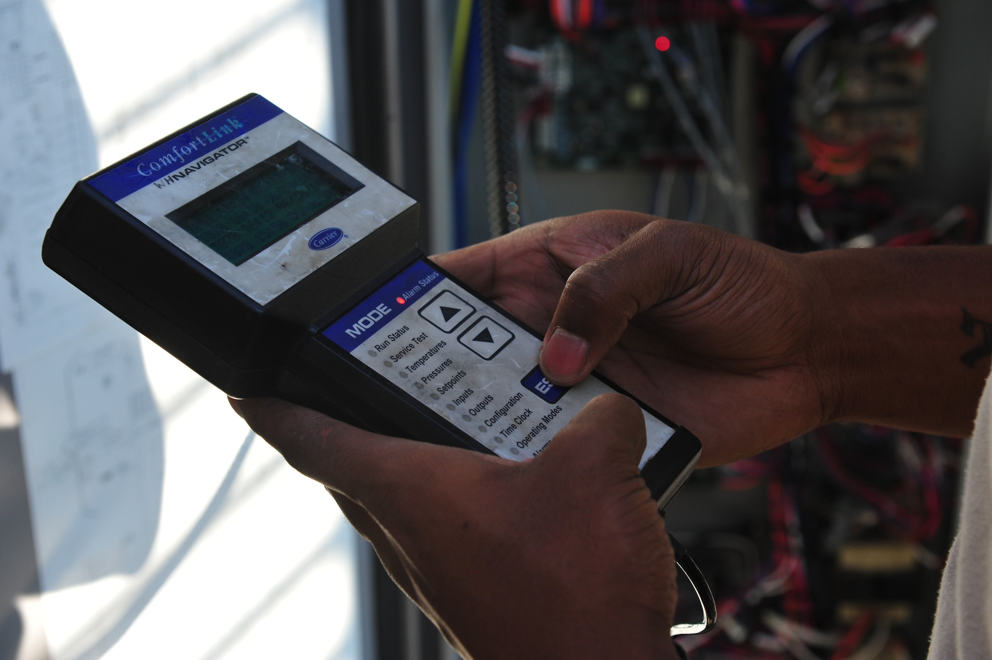 Staff Sgt. Myron Gordon, 8th Civil Engineer Squadron Heating, Ventilation, Air Conditioning and Refrigeration shop journeyman, uses a Comfortlink to navigate through the controls on an air chiller at Kunsan Air Base, Republic of Korea, June 30, 2014. The device is used by HVAC technicians to reset alarms and check on the status or required maintenance for chiller units. Specialized tools and training help 8th CES HVAC Airmen accomplish the mission of keeping mission essential facilities and equipment cool and ready for use. (U.S. Air Force photo by 1st Lt. Earon Brown/Released)