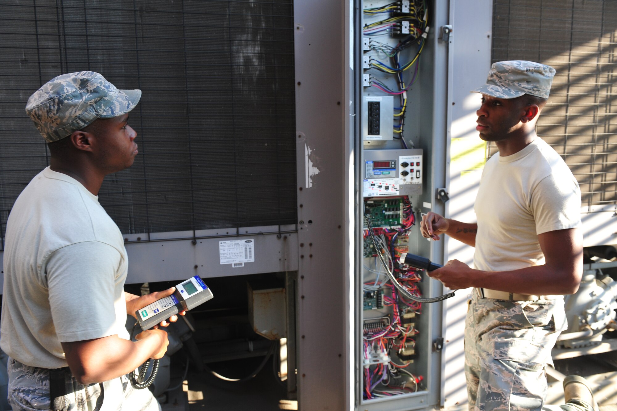 Staff Sgt. Wava Johnson (left), 8th Civil Engineer Squadron Heating, Ventilation, Air Conditioning and Refrigeration shop craftsman, and Staff Sgt. Myron Gordon, 8th CES HVAC journeyman, address issues with a chiller unit at the fitness center of Kunsan Air Base, Republic of Korea, June 30, 2014. The most typical work orders for HVAC Airmen regard malfunctioning air-conditioning units or water boilers, keeping 8th CES HVAC technicians busy around the clock. (U.S. Air Force photo by 1st Lt. Earon Brown/Released)