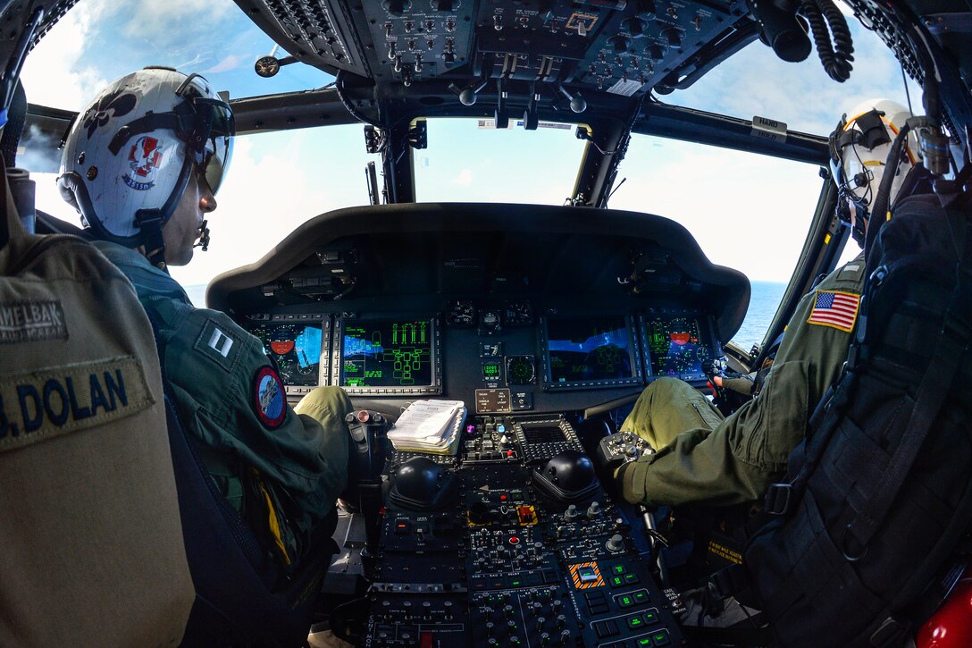 U.S. Navy Lt. Dan Dolan, left, and U.S. Navy Lt. j.g. Matt Debbink assigned to the “Black Knights” of Helicopter Combat Support Squadron 4, pilot a MH-60S Sea Hawk helicopter, attached to Carrier Air Wing 2, embarked on the USS Ronald Reagan in the Pacific Ocean, June 23, 2014. The Ronald Reagan is en route to Hawaii for Rim of the Pacific 2014. 