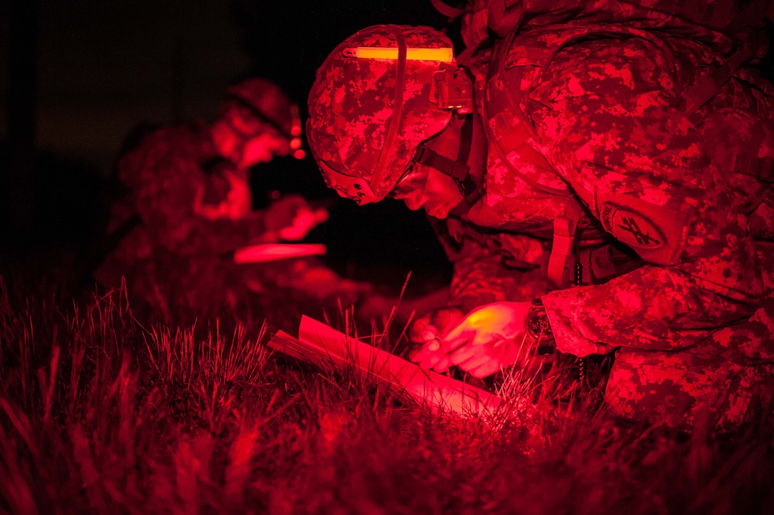 As seen through a night-vision device Army Staff Sgt. Kristopher Stallard checks navigations during the Night Land Navigation event at the 2014 U.S. Army Reserve Best Warrior Competition on Joint Base McGuire-Dix-Lakehurst, N.J., June 24, 2014. The warriors were dropped off and had four hours to plot and find their map points in complete darkness. Stallard is a healthcare specialist assigned to the U.S. Army Civil Affairs and Psychological Operations Command. 