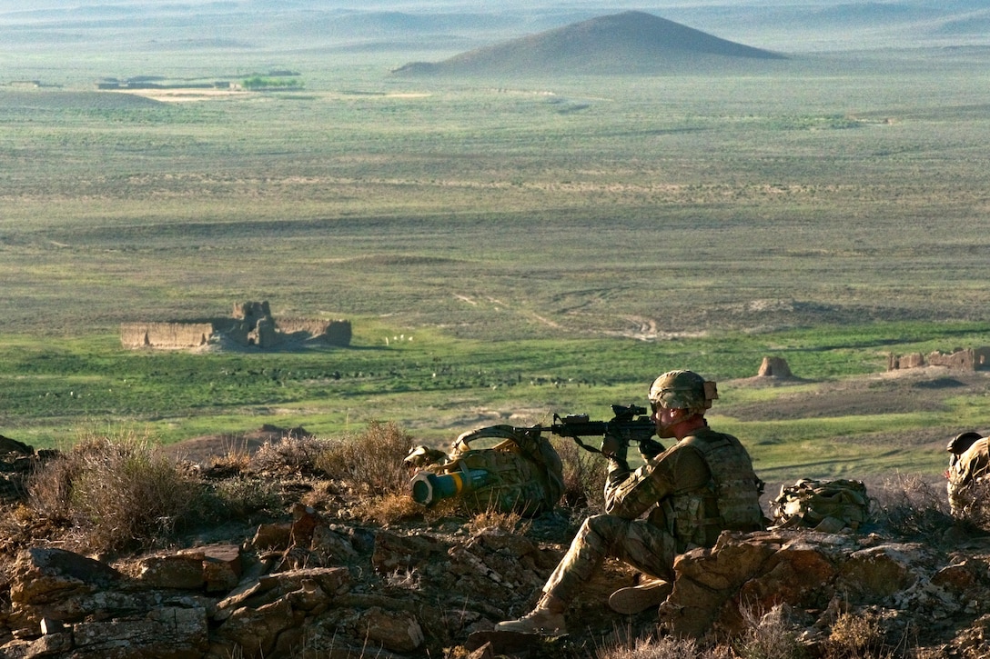 U.S. Army Spc. Eric Leveault scans his sector while providing security and monitors movement near an observation point overlooking the Darwazgay pass in Afghanistan's Zabul province, June 24, 2014. Leveault, an infantryman, is assigned to the 82nd Airborne Division's 2nd Battalion, 504th Parachute Infantry Regiment. The U.S. soldiers were participating in a joint air assault mission with Afghan soldiers. 