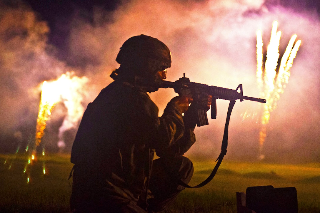 Army Sgt. Camille Kleparek fires her M4 rifle in the night-fire qualification event amid explosions and tracers during the 2013 Army Reserve Best Warrior competion on Fort McCoy, Wis., June 26, 2013. 