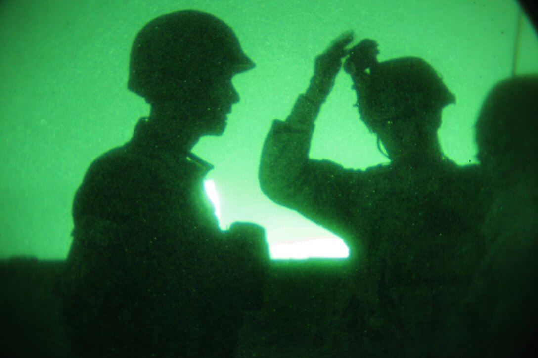 A U.S. soldier, center, briefs an Afghan soldier during an air assault mission near Bagram Airfield in Afghanistan's Parwan province, June 21, 2014. 