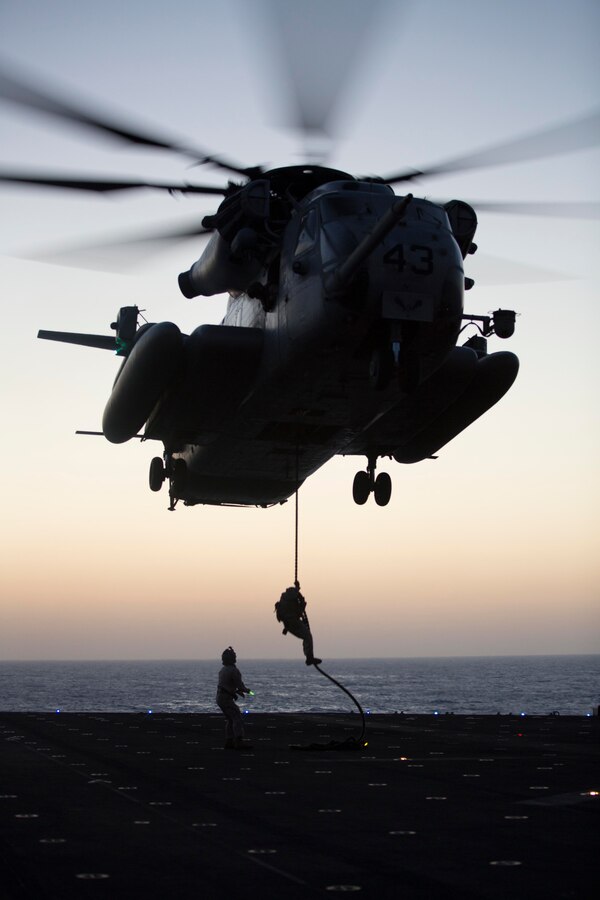 A U.S. Marine with Battalion Landing Team 1st Battalion, 6th Marine Regiment, 22nd Marine Expeditionary Unit (MEU), fast ropes out of a CH-53E Super Stallion helicopter during a fast rope and rappel training exercise aboard the USS Bataan (LHD 5), at sea, June 24, 2014. Elements of the 22nd MEU, embarked aboard Bataan, are operating in the U.S. 6th Fleet area of operations to augment U.S. Crisis Response forces in the region. (U.S. Marine Corps photo by Sgt. Alisa J. Helin/Released)