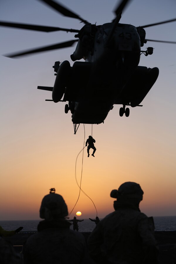 A U.S. Marine with Battalion Landing Team 1st Battalion, 6th Marine Regiment, 22nd Marine Expeditionary Unit (MEU), rappel out of a CH-53E Super Stallion helicopter during a fast rope and rappel training exercise aboard the USS Bataan (LHD 5), at sea, June 24, 2014. Elements of the 22nd MEU, embarked aboard Bataan, are operating in the U.S. 6th Fleet area of operations to augment U.S. Crisis Response forces in the region. (U.S. Marine Corps photo by Sgt. Alisa J. Helin/Released)