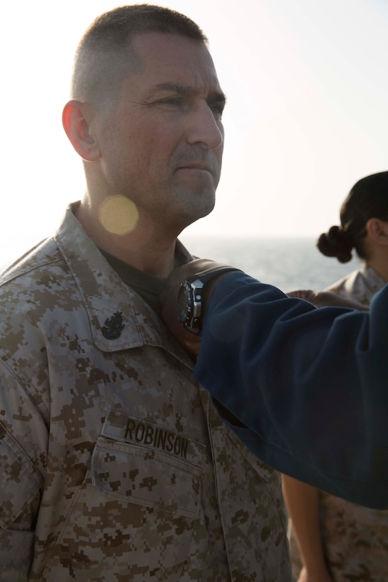 U.S. Navy Senior Chief Hospitalman Reagen Robinson, 22nd Marine Expeditionary Unit (MEU) senior enlisted medical representative and native of Roxana, Ill., is pinned with his enlisted service warfare pin aboard USS Bataan (LHD 5), at sea, June 26, 2014. Elements of the 22nd MEU, embarked aboard Bataan, are operating in the U.S. 6th Fleet area of operations to augment U.S. Crisis Response forces in the region. (U.S. Marine Corps photo by Sgt. Alisa J. Helin/Released)
