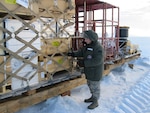 The Kentucky Air National Guard's Tech. Sgt. Ray Graves inspects outbound cargo on an ice runway Dec. 28, 2011, while deployed to McMurdo Station, Antarctica. Graves supported Operation Deep Freeze as NCOIC of joint inspection and rigging for the third rotation of the 2011-12 Deep Freeze season.
