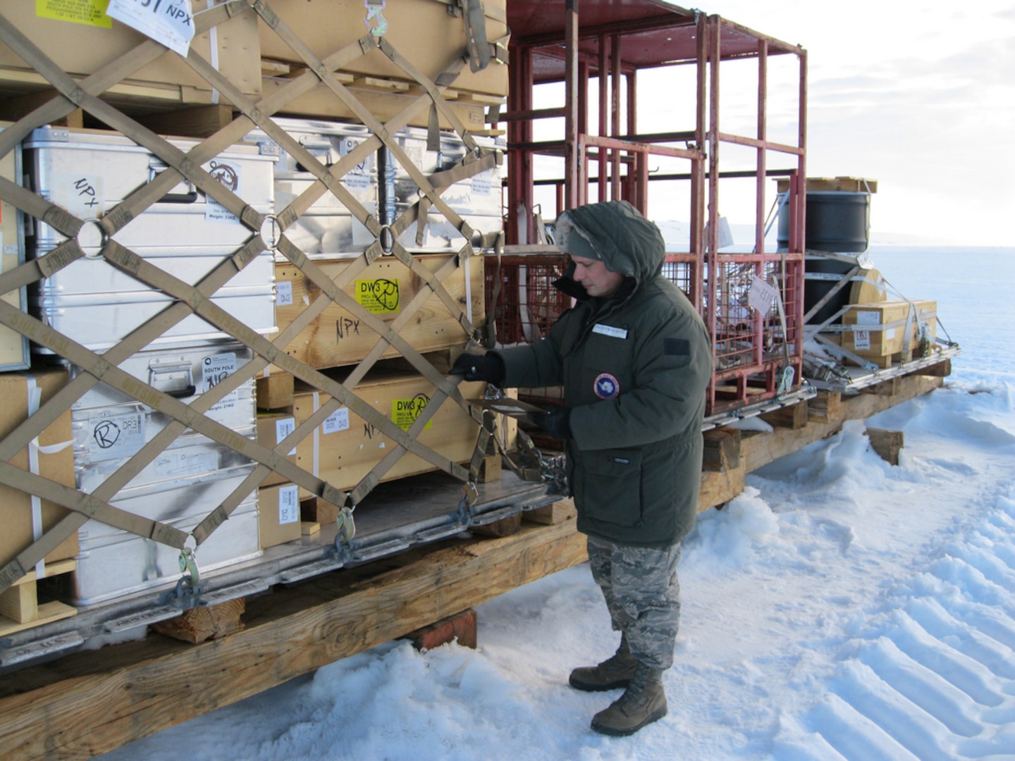 The Kentucky Air National Guard's Tech. Sgt. Ray Graves inspects outbound cargo on an ice runway Dec. 28, 2011, while deployed to McMurdo Station, Antarctica. Graves supported Operation Deep Freeze as NCOIC of joint inspection and rigging for the third rotation of the 2011-12 Deep Freeze season.