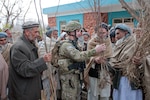 Army 1st. Lt. Andrew Webster, the project manager for the Kansas Agribusiness Development Team, and Ismail Dawlatzai, director of Agriculture, Irrigation, and Livestock, distribute fruit bearing trees at the Alingar Agriculture Extension Center, Feb. 1, 2012. Around 2,400 saplings were given to the approximately 200 elders from villages around Alingar district.